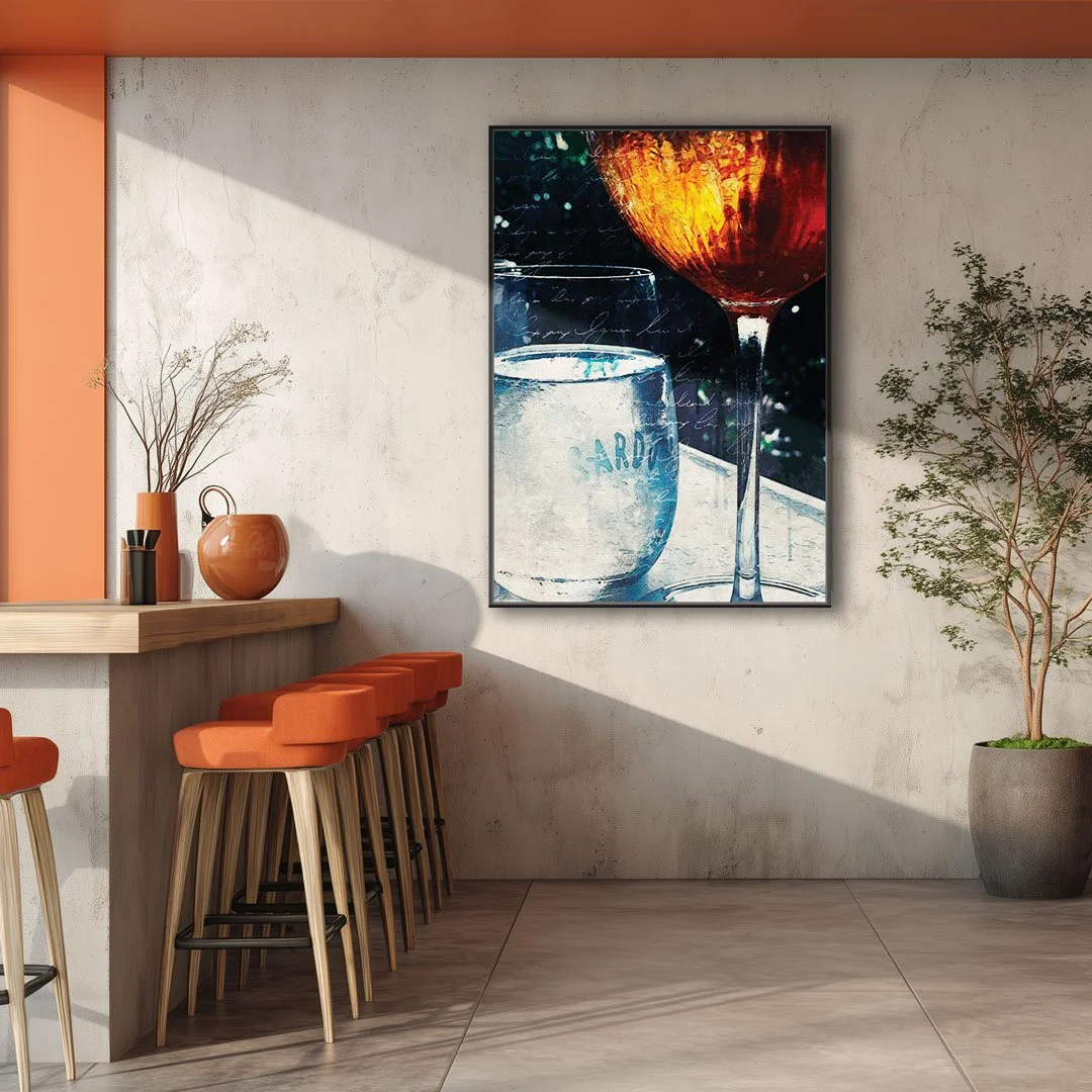Interior of a modern room with a bar-height counter, orange cushioned stools, a large wall art depicting wine glasses, and a potted plant.