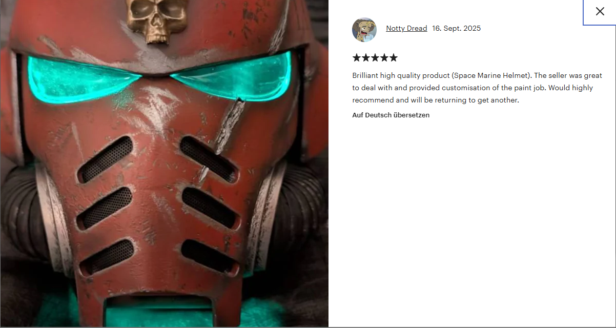 Close-up of a Blood Angels Space Marine helmet with glowing Green eyes, red color, and a skull decoration on top.