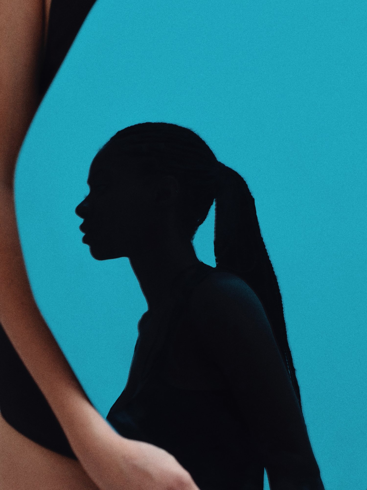 Silhouette of a woman with a ponytail against a blue background.