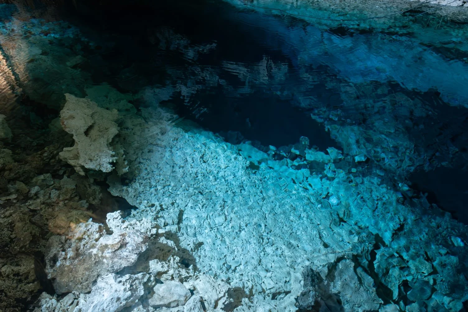 Sunlight illuminating the crystal-clear waters inside Paje Cave in Zanzibar.