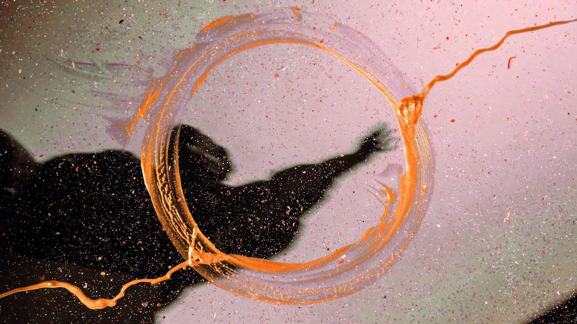 Ein schwarzer Schatten, der gegen einen rosa Hintergrund springt, umgeben von glitzerndem Staub, mit einer orangefarbenen Kreidezeichnung.