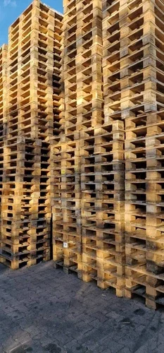 Stapel von Holzpaletten vor einem Gebäude