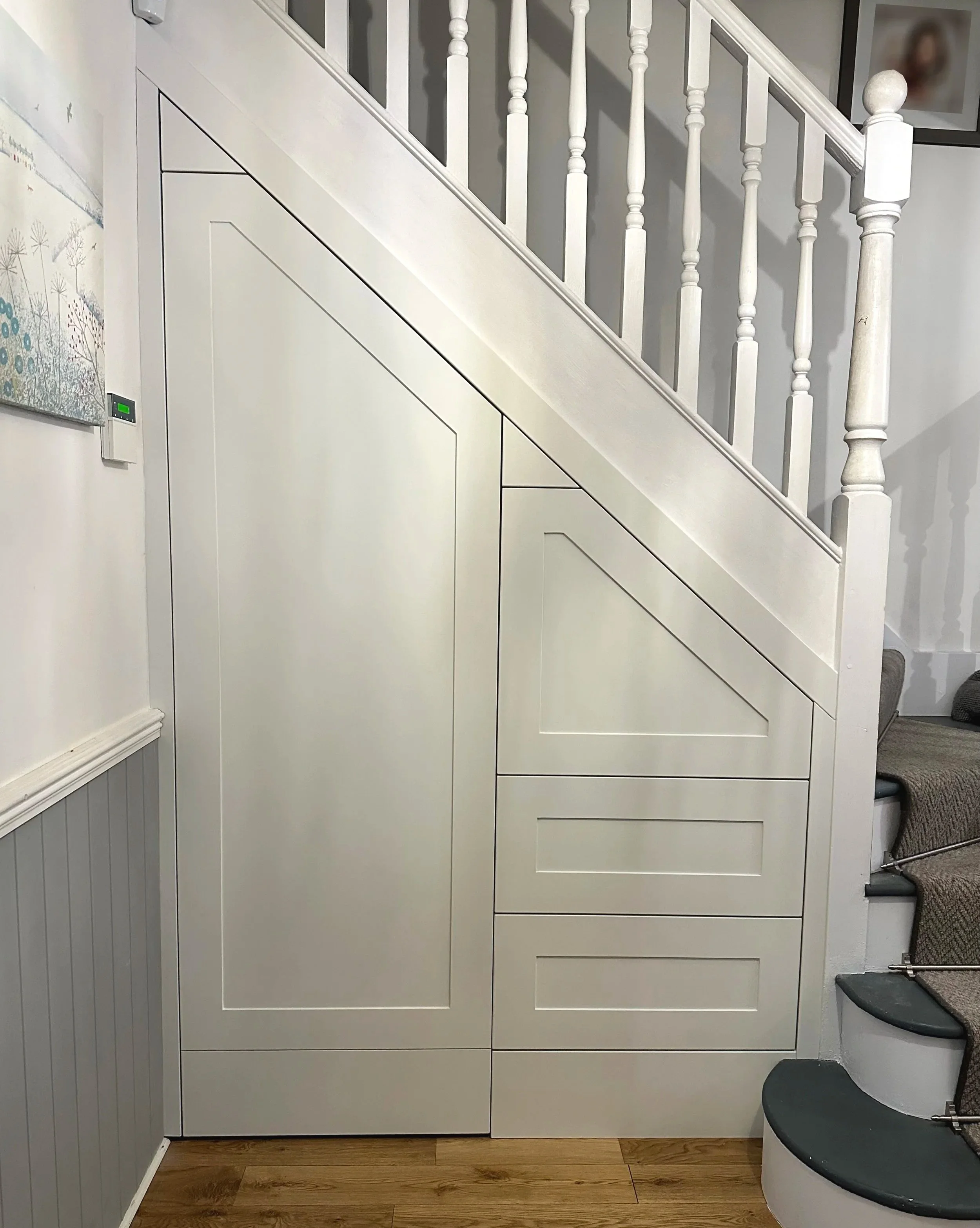 Under stairs fitted storage - push to open drawers and door, spray finished in pure white with lacquered oak veneered interior and onyx Blum hardware