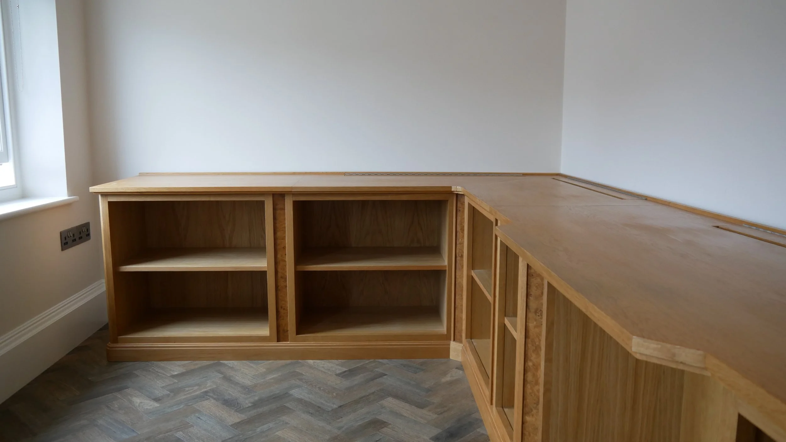 Bespoke home office desking. Oak with burr oak detailing. Featuring hinged cable access points with brush strips. Subtle art deco/early modernist styling. 