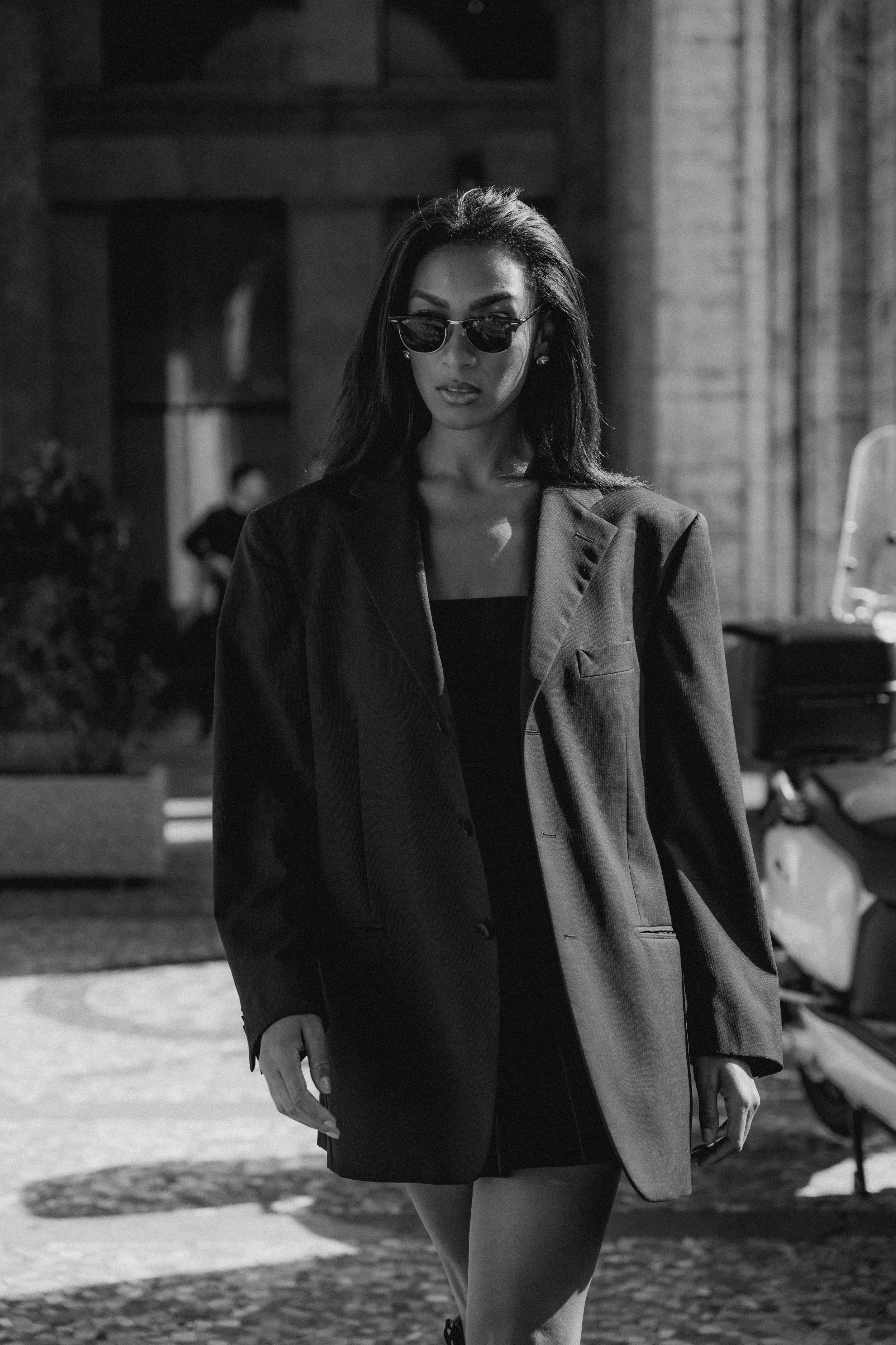 Black and white night fashion portrait woman sunglasses blazer skirt Milan street 