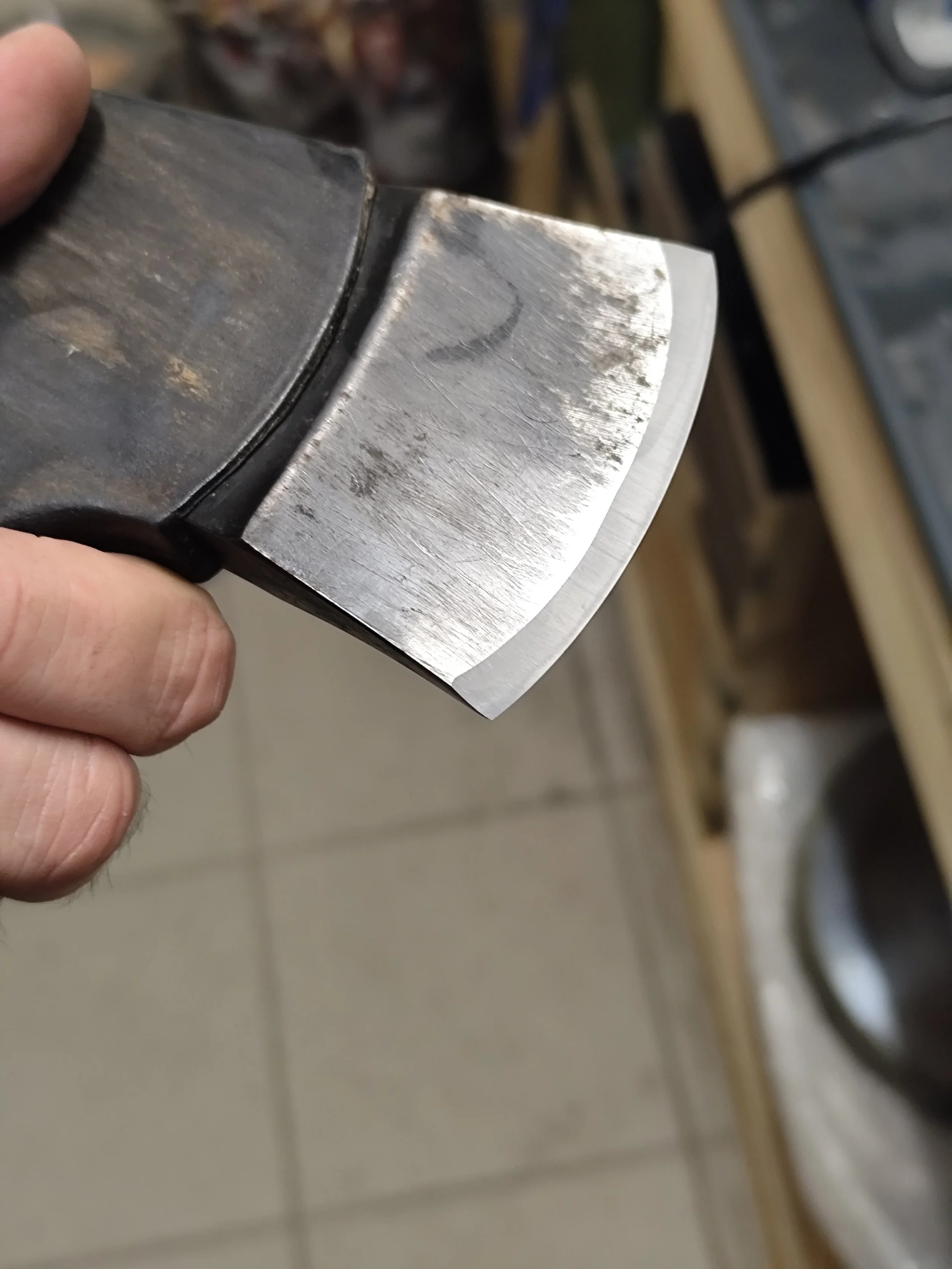 Ein Handstück eines Messers mit einer scharfen Klinge, in einer Werkstatt.