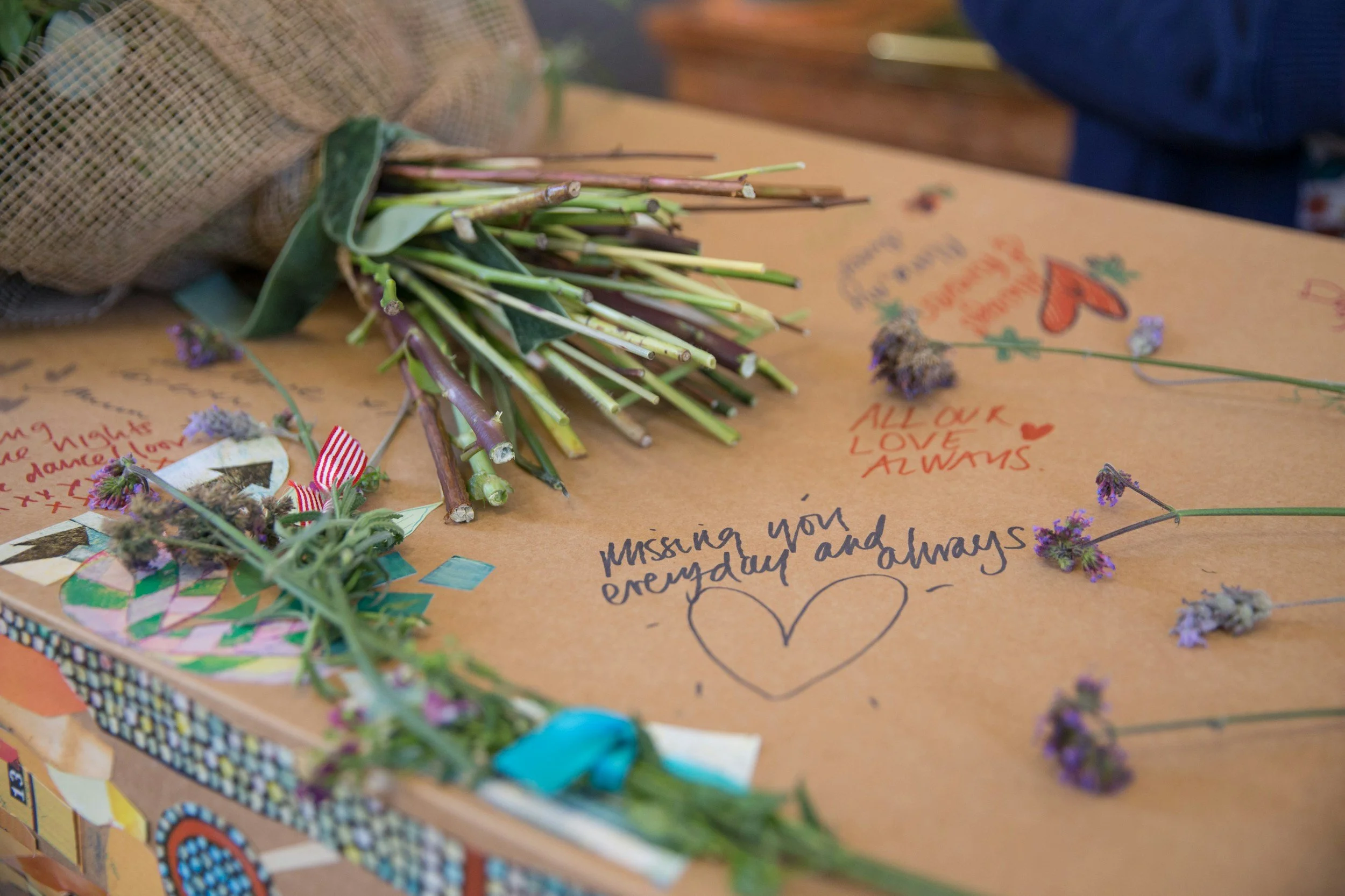 Bouquet of flowers and handwritten messages on a cardboard surface.