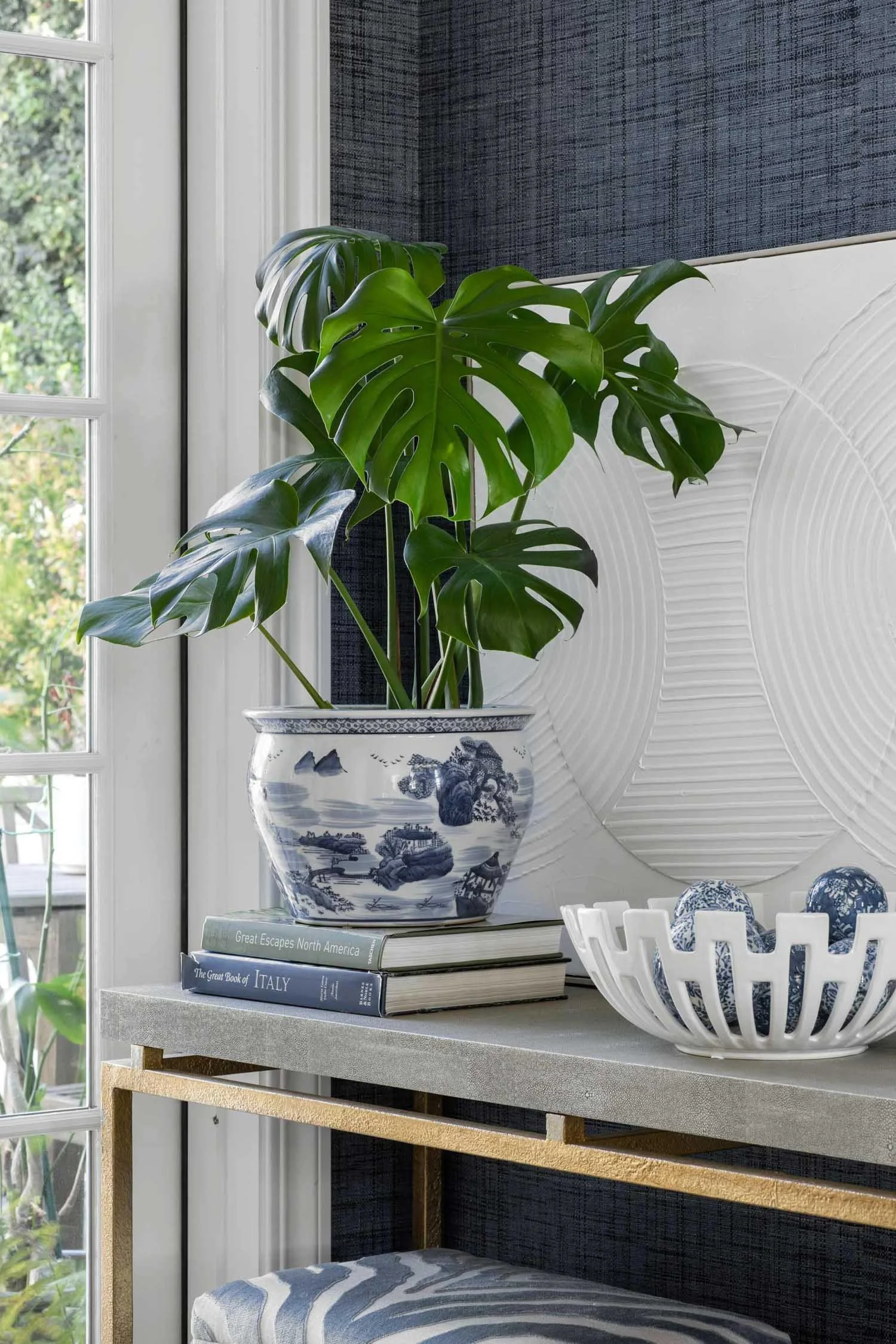Elegant stone table in entryway with plants and artwork, designed by Julie Beuerlein, interior designer