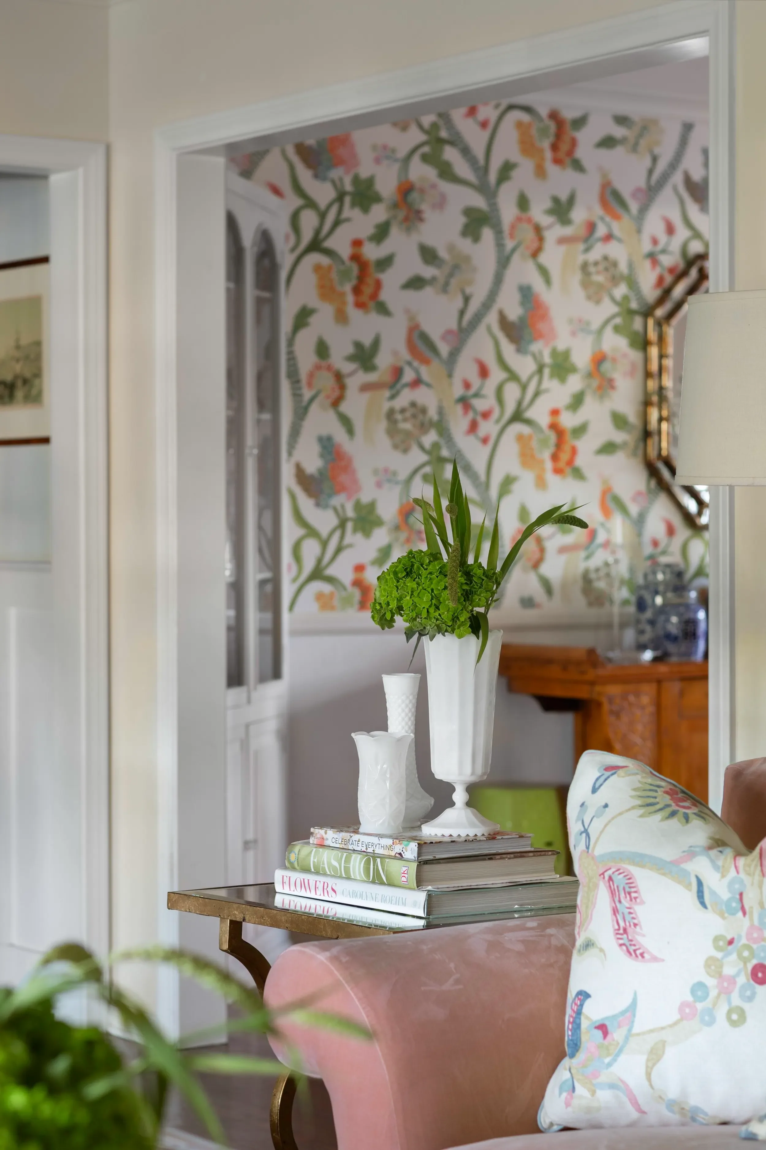 Layered living room with pink sofa, floral textiles, brass accents, and colorful wallpaper in Palos Verdes Estates by JKB Home Design