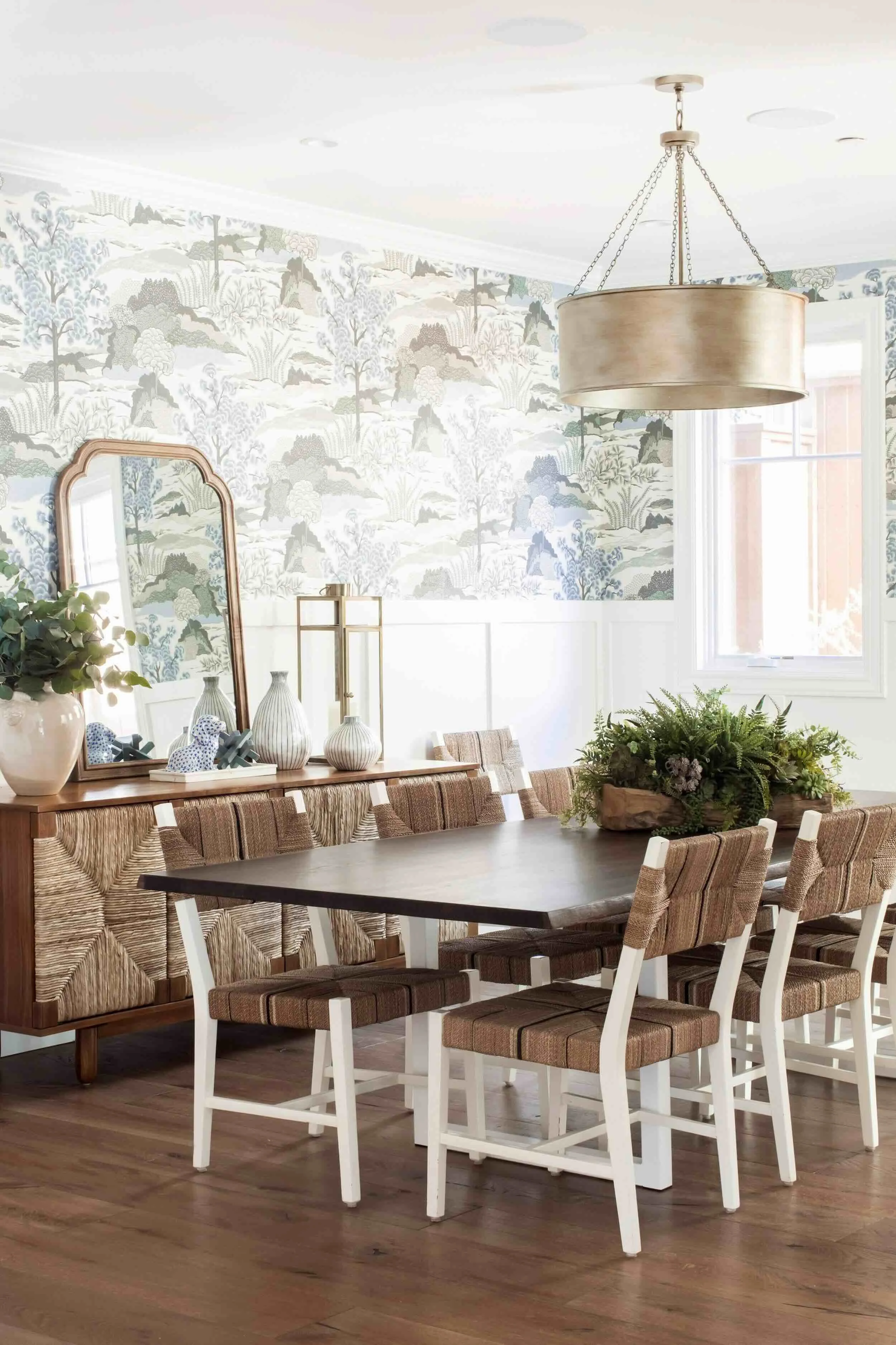 Palos Verdes Estates dining room with botanical wallpaper, woven chairs, wainscoting, and modern drum chandelier by JKB Home Design