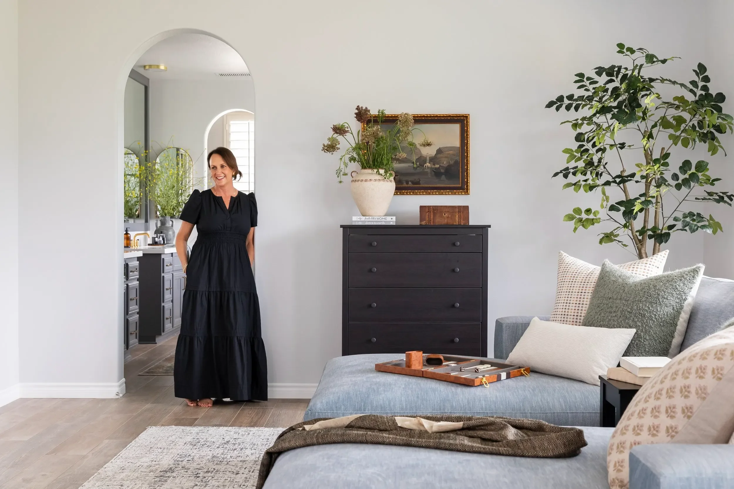 Interior designer Julie Beuerlein in a refined living room with blue chaise seating and layered natural accents
