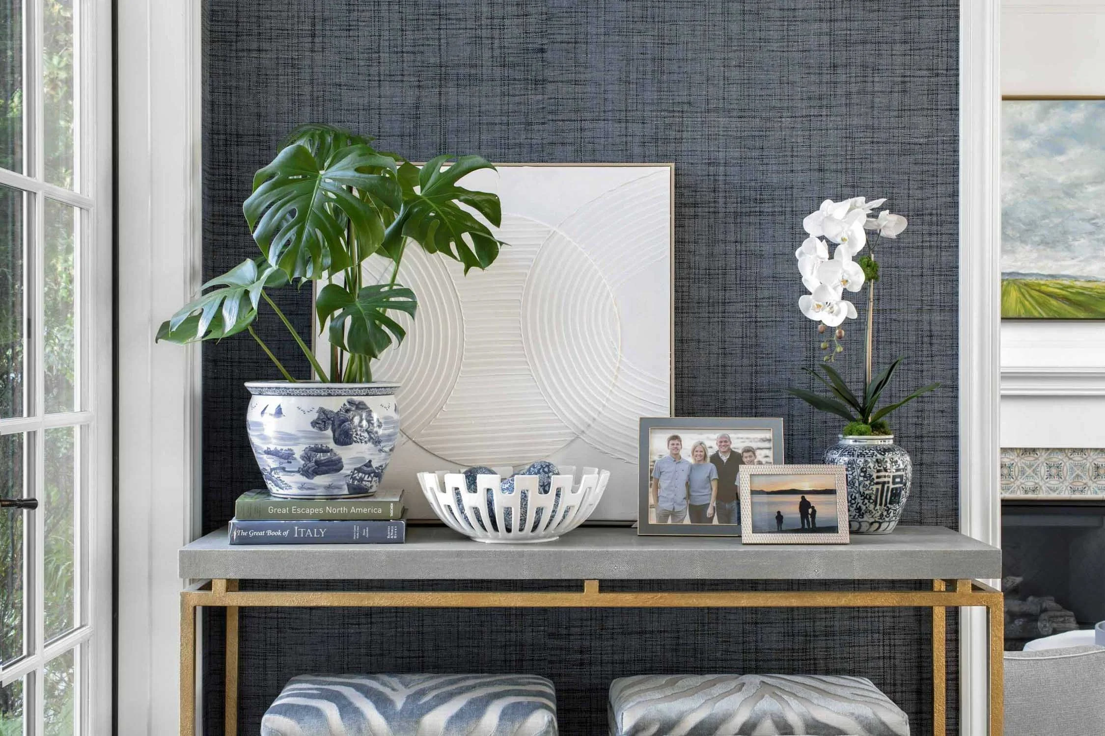 Formal entry with styled table, upholstered stools, and classic details, designed by Julie Beuerlein, interior designer