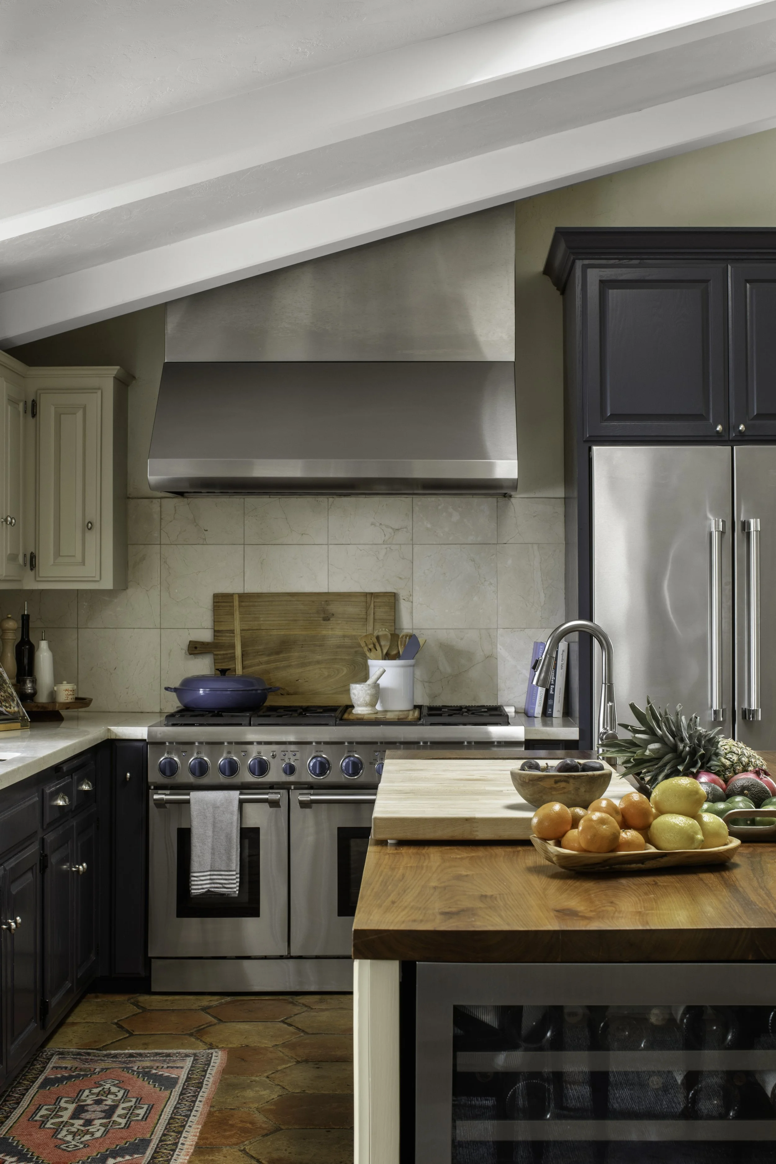 Warm kitchen with square tile walls and wood island in Palos Verdes Estates, designed by Julie Beuerlein