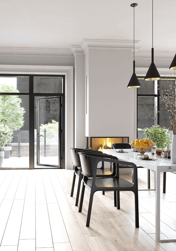 Modern dining area with wood-look flooring, black chairs, pendant lights, and large windows