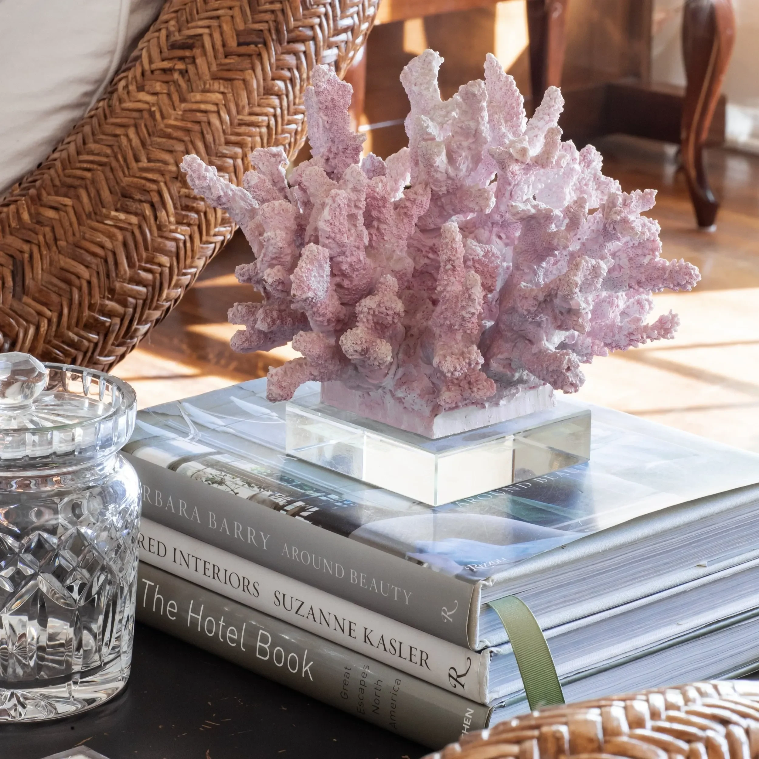 Stacked interior design coffee table books styled with pink coral and decorative accessories by JKB Home Design