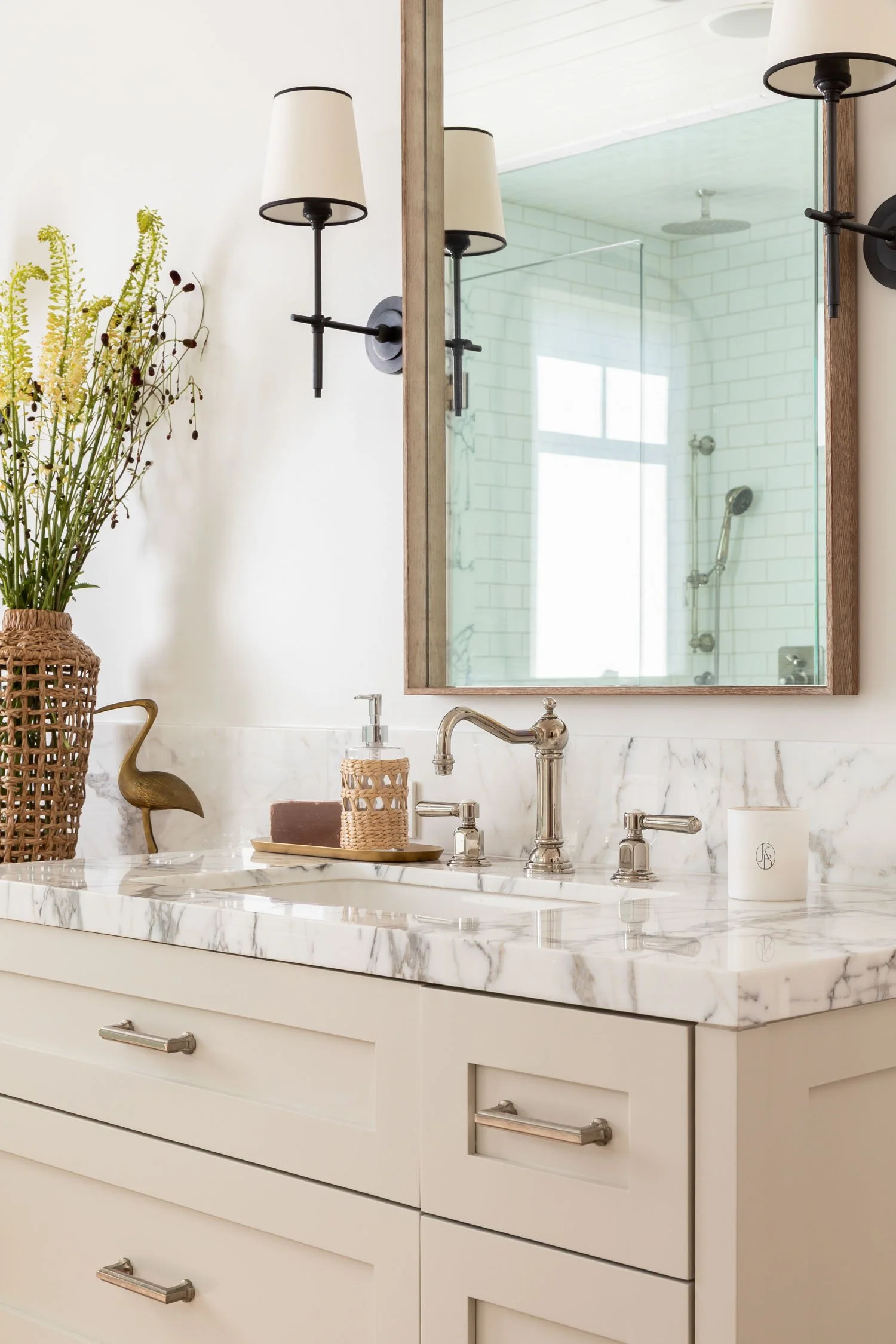 Marble bathroom vanity with polished nickel fixtures and wood-framed mirror in a Manhattan Beach home by JKB Home Design