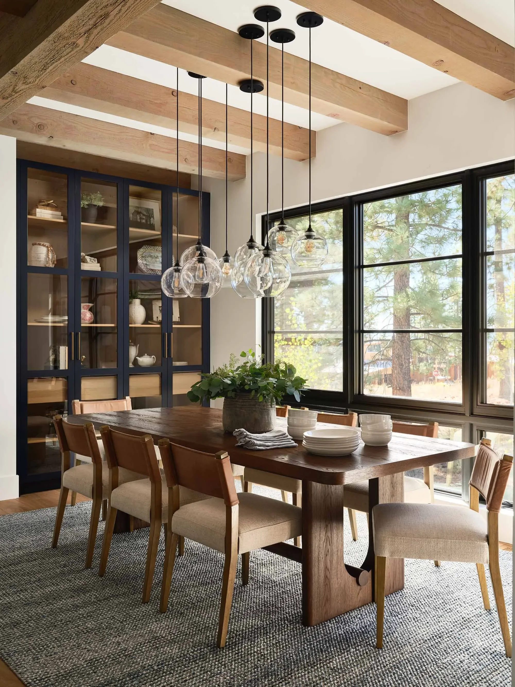 Modern mountain dining room with globe pendants and exposed wood beams, designed by Julie Beuerlein, interior designer
