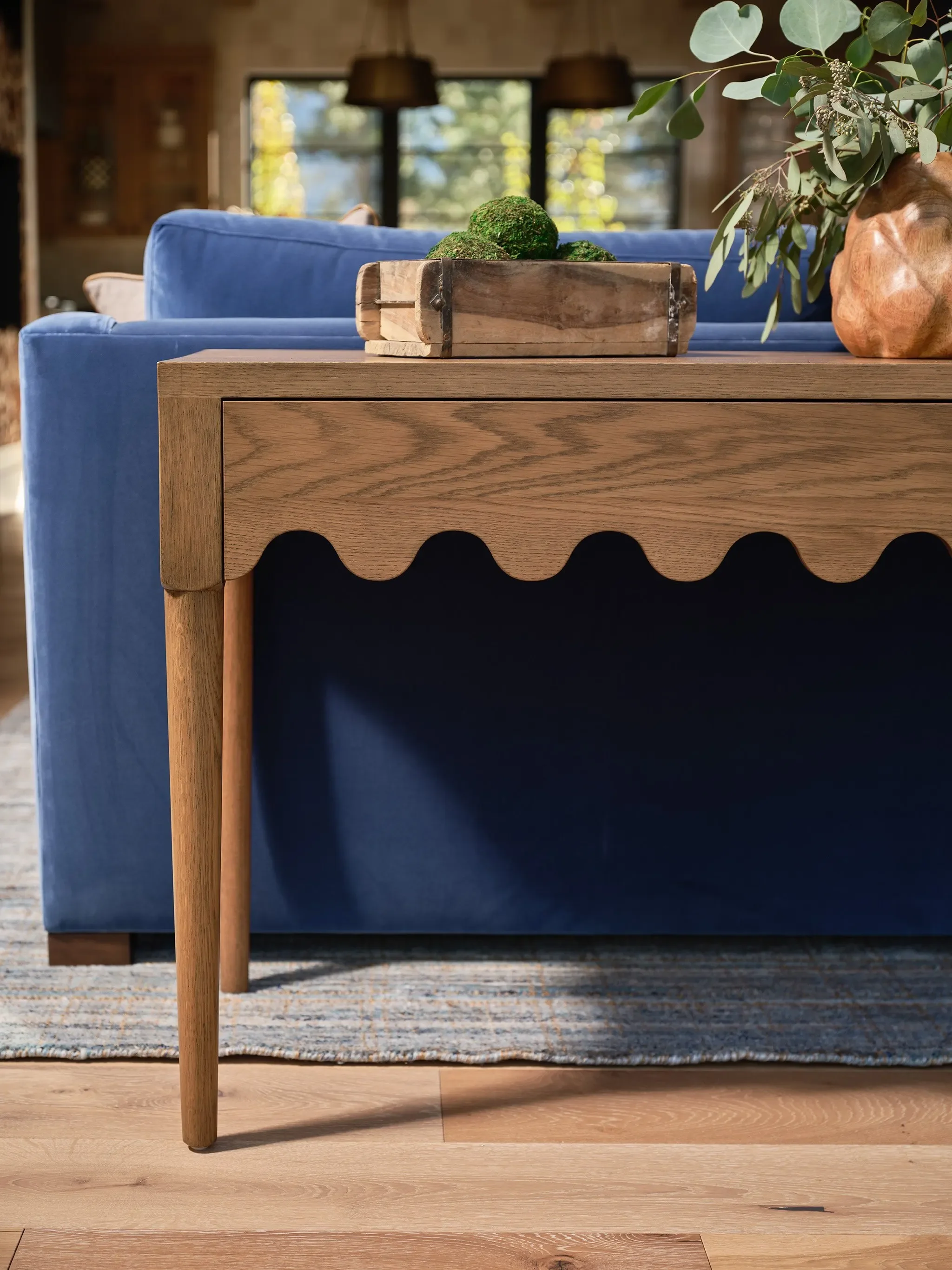 Blue sofa and sculptural wood console with natural accents in a Clear Creek Tahoe home, designed by JKB Home Design