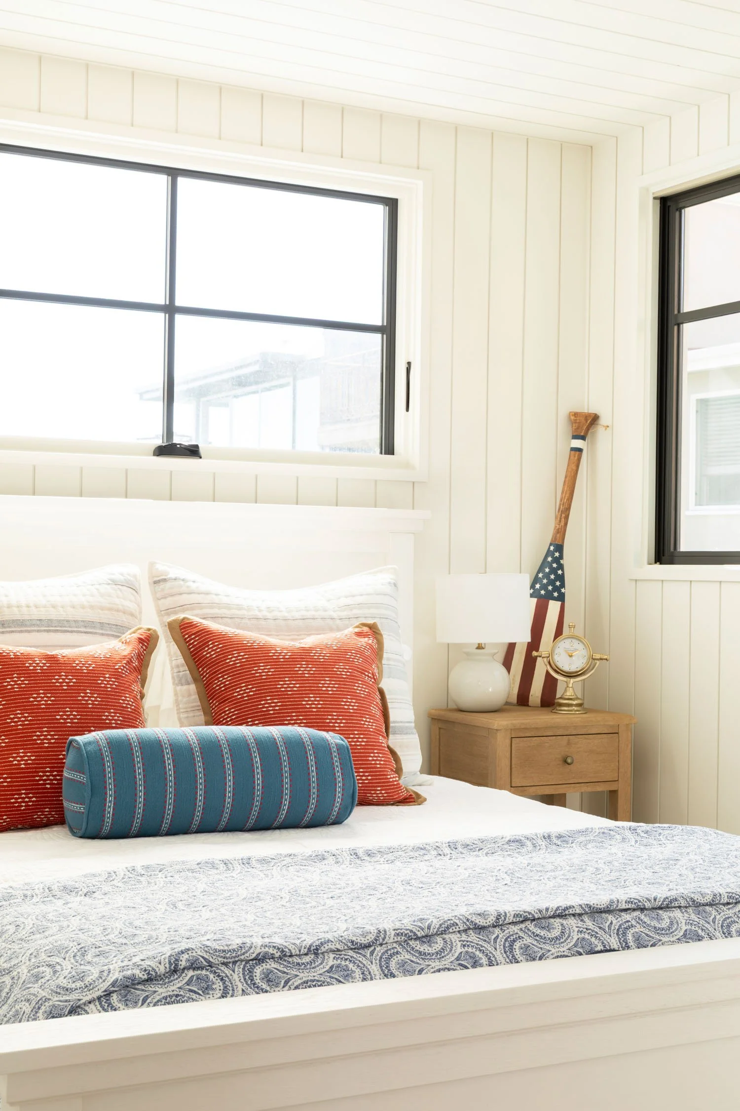 Bright Manhattan Beach bedroom with red and blue patterned bedding and coastal accents, designed by JKB Home Design