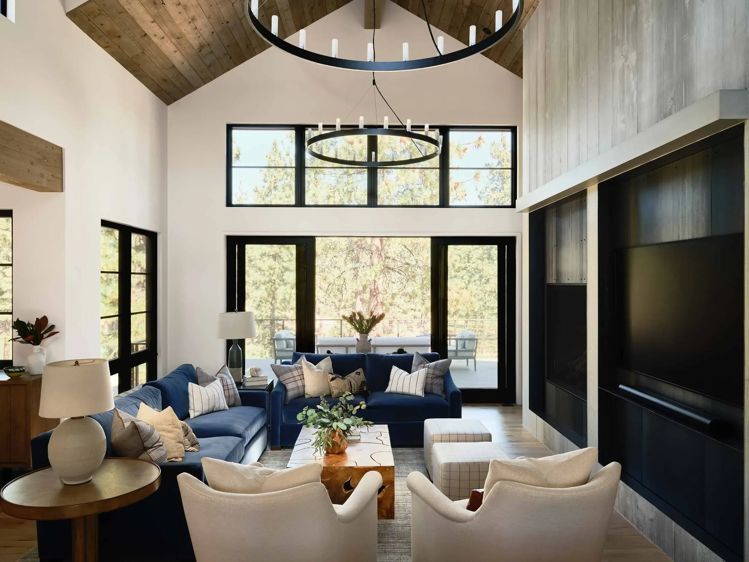 Rustic-modern living space with wood coffee table and cream armchairs, designed by Julie Beuerlein, interior designer
