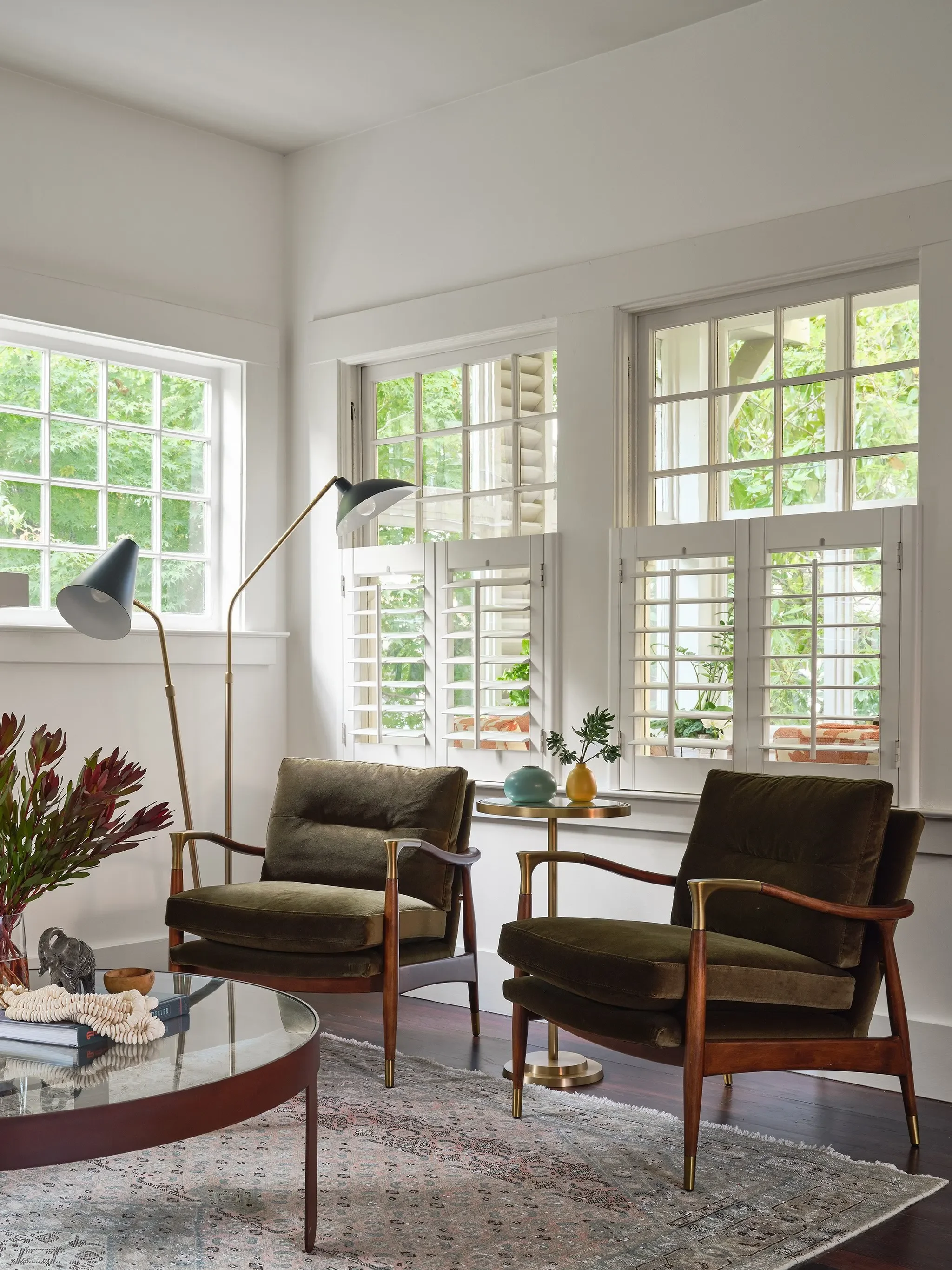 Olive green mid-century armchairs with brass floor lamps in an eclectic San Anselmo living room by JKB Home Design