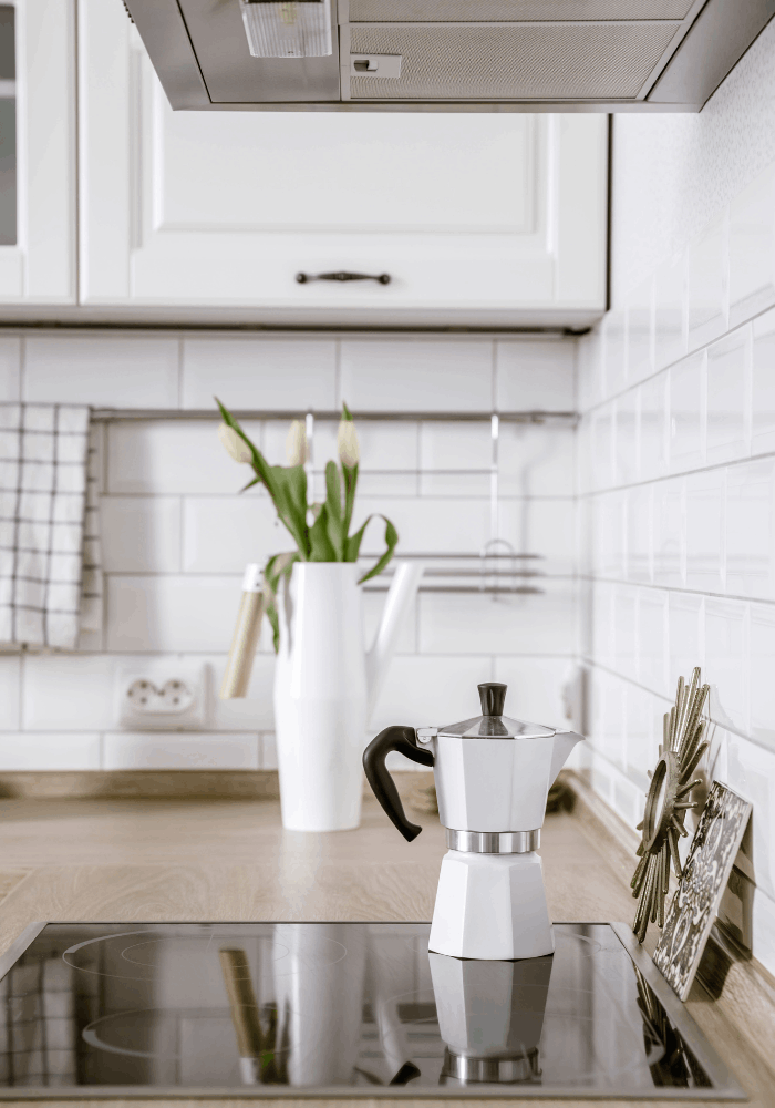 Bright white kitchen with fresh flowers and simple countertop accessories for a clean spring refresh
