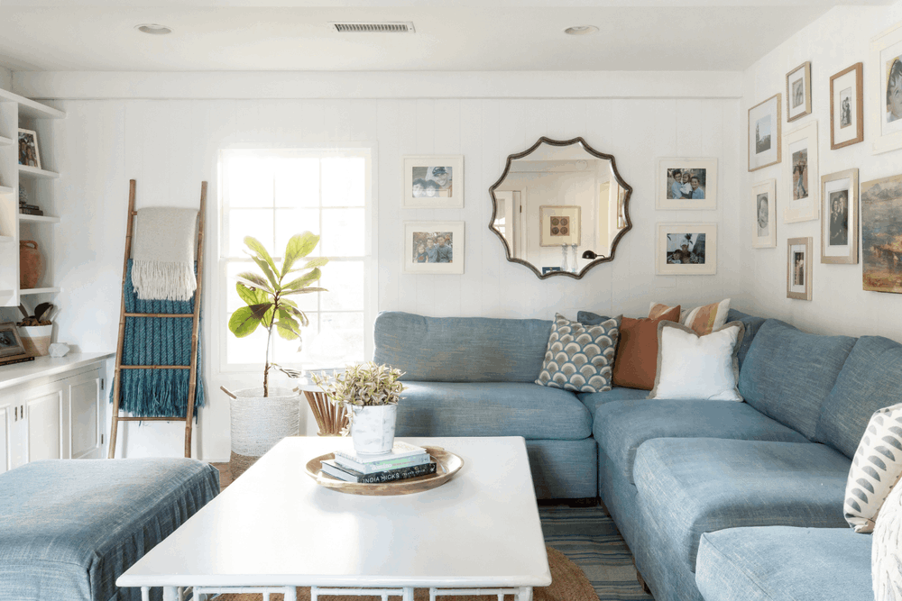 Bright Palos Verdes Estates family room with custom blue sectional, gallery wall, and layered rugs by JKB Home Design