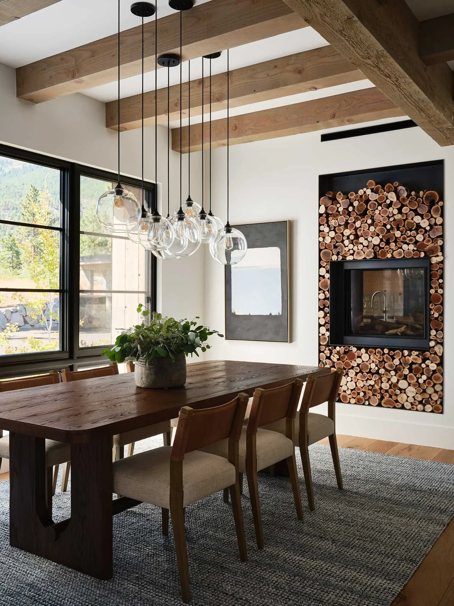 Dining room with exposed beams and custom fireplace, designed by JKB Home Design in Tahoe