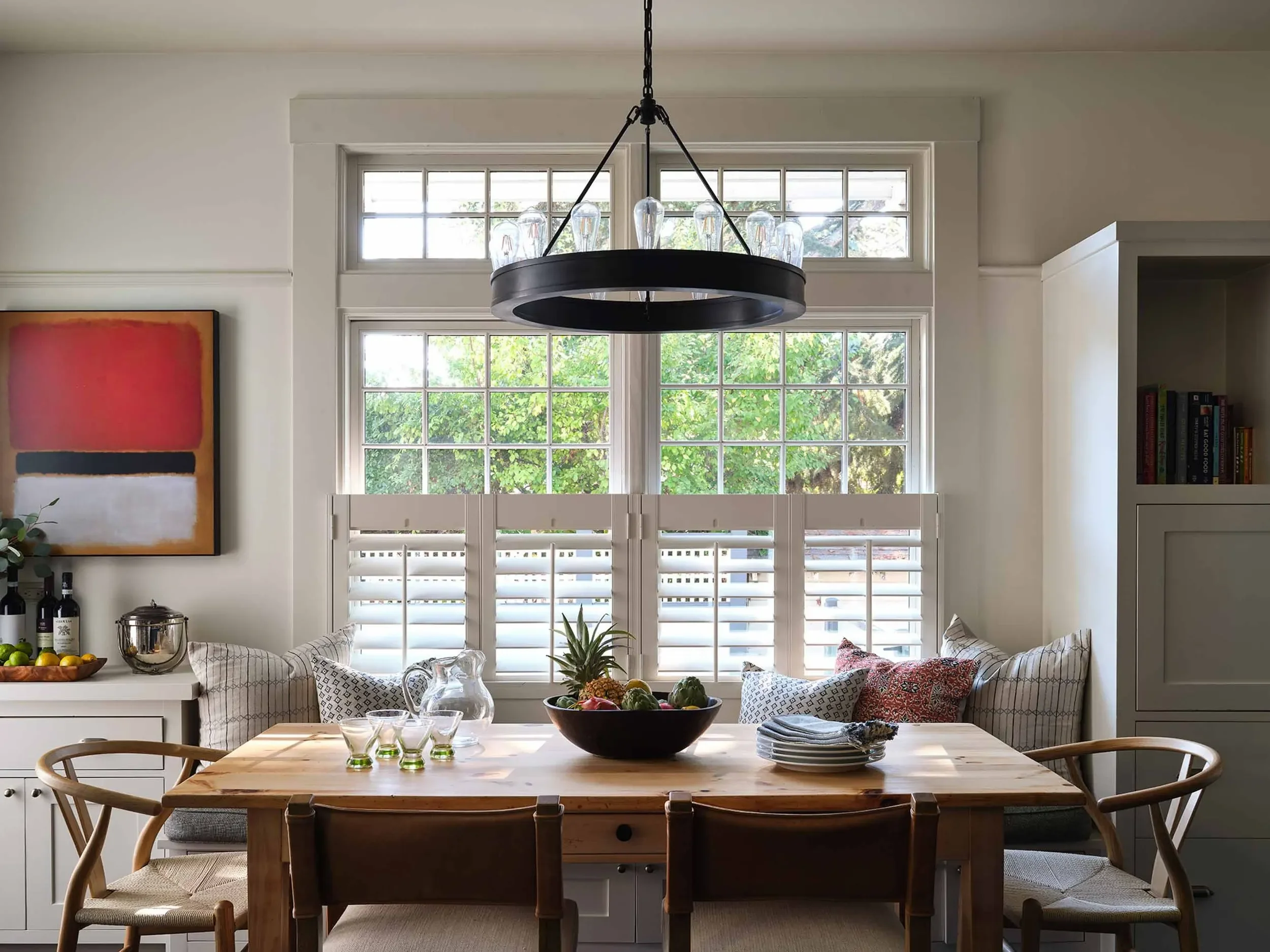 Dining room with classic wood table and red accents, designed by Julie Beuerlein, South Bay interior designer