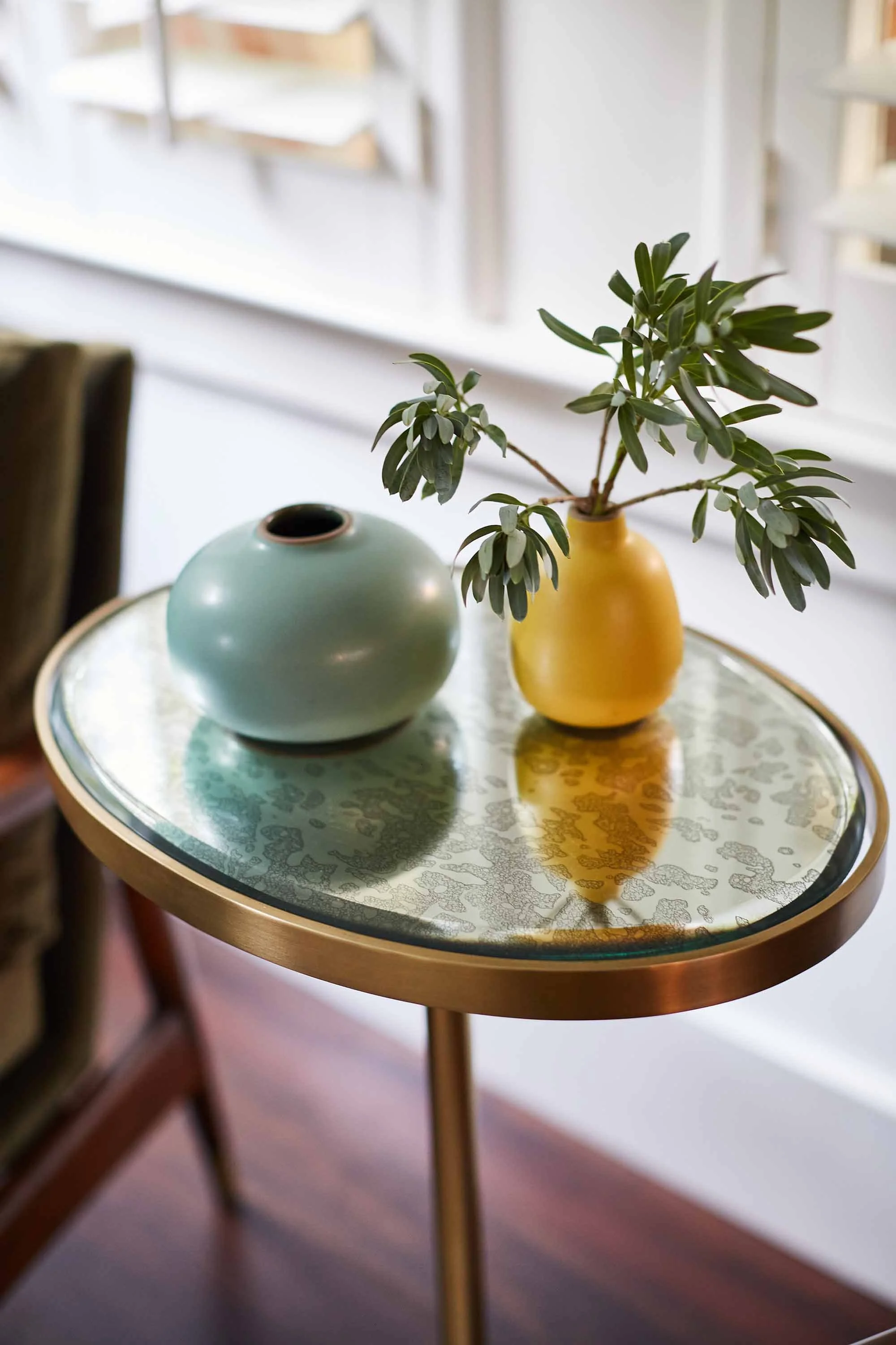 Glass table with colorful vases, designed by Julie Beuerlein, interior designer