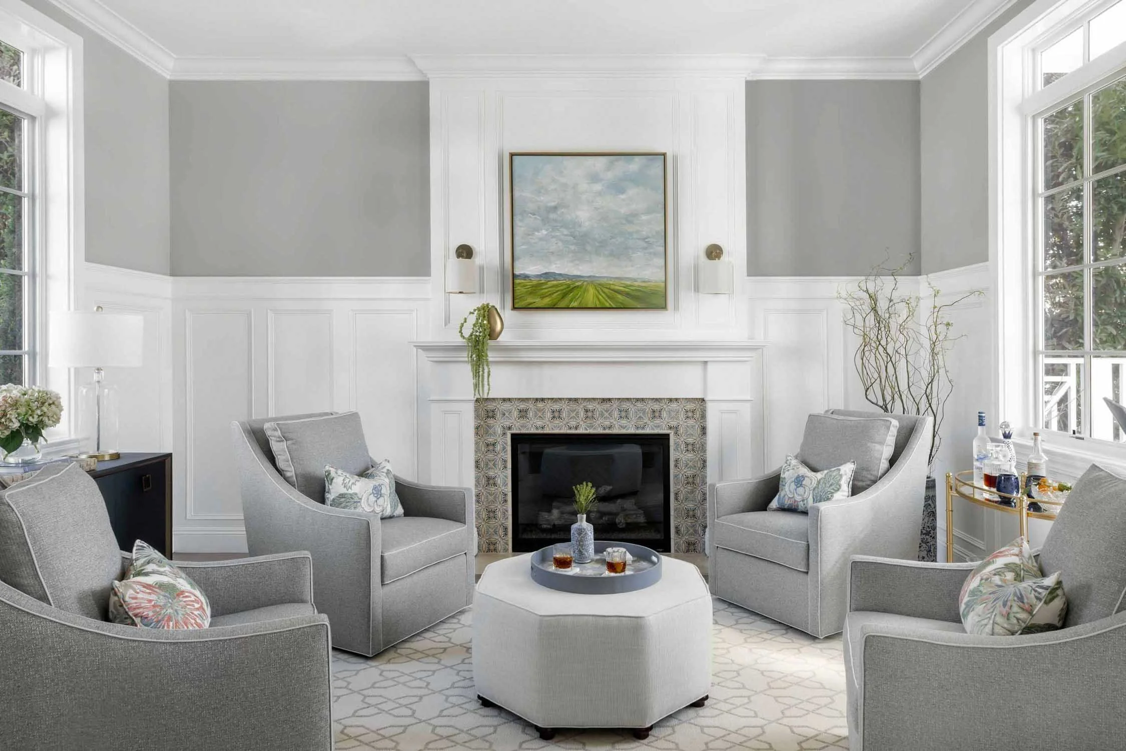 Wainscoted walls and patterned tile fireplace in luxury parlor, designed by JKB Home Design