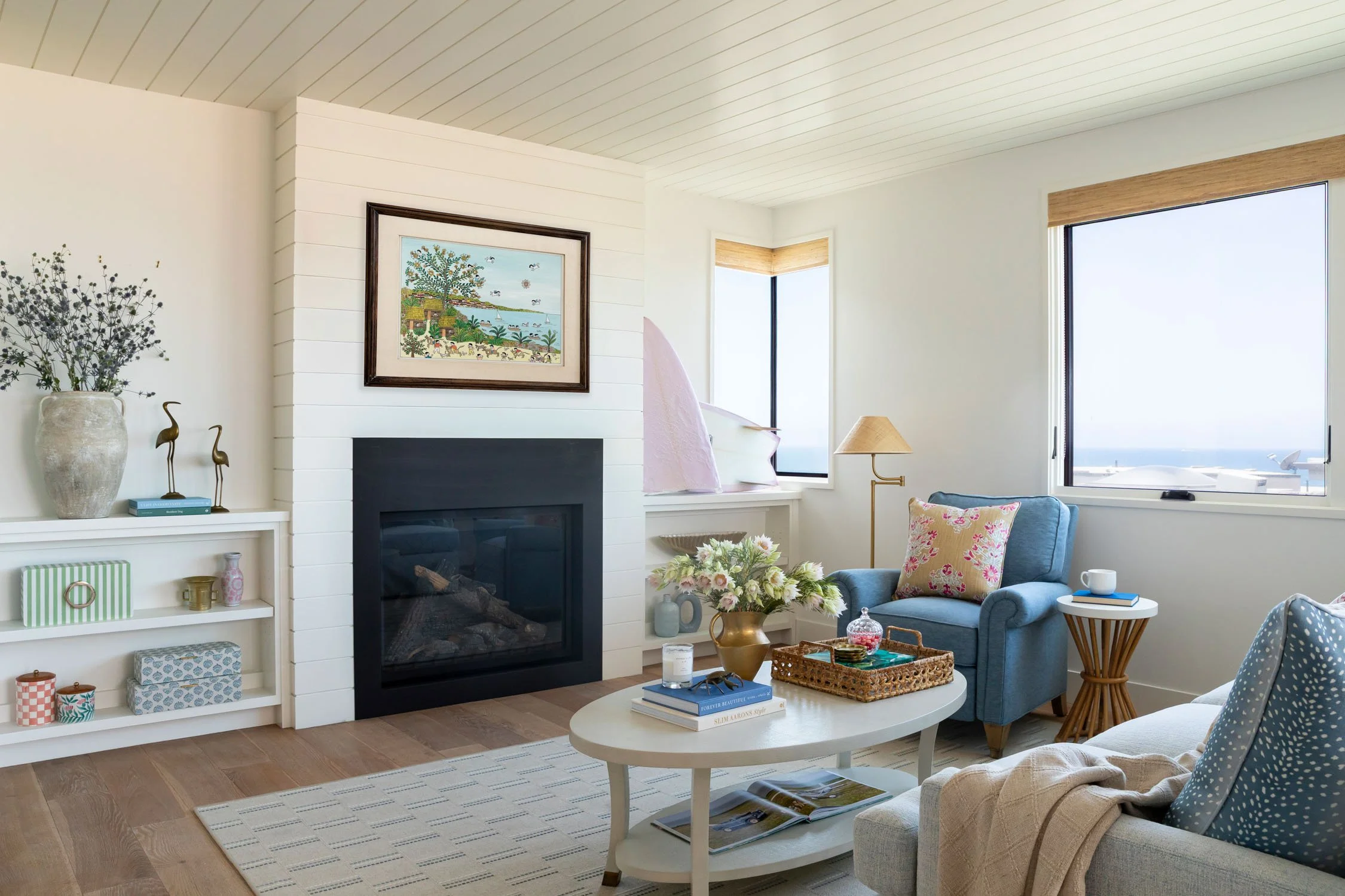 Coastal living room with fireplace, colorful textiles, and thoughtfully styled built-ins in a Manhattan Beach home designed by Julie Beuerlein