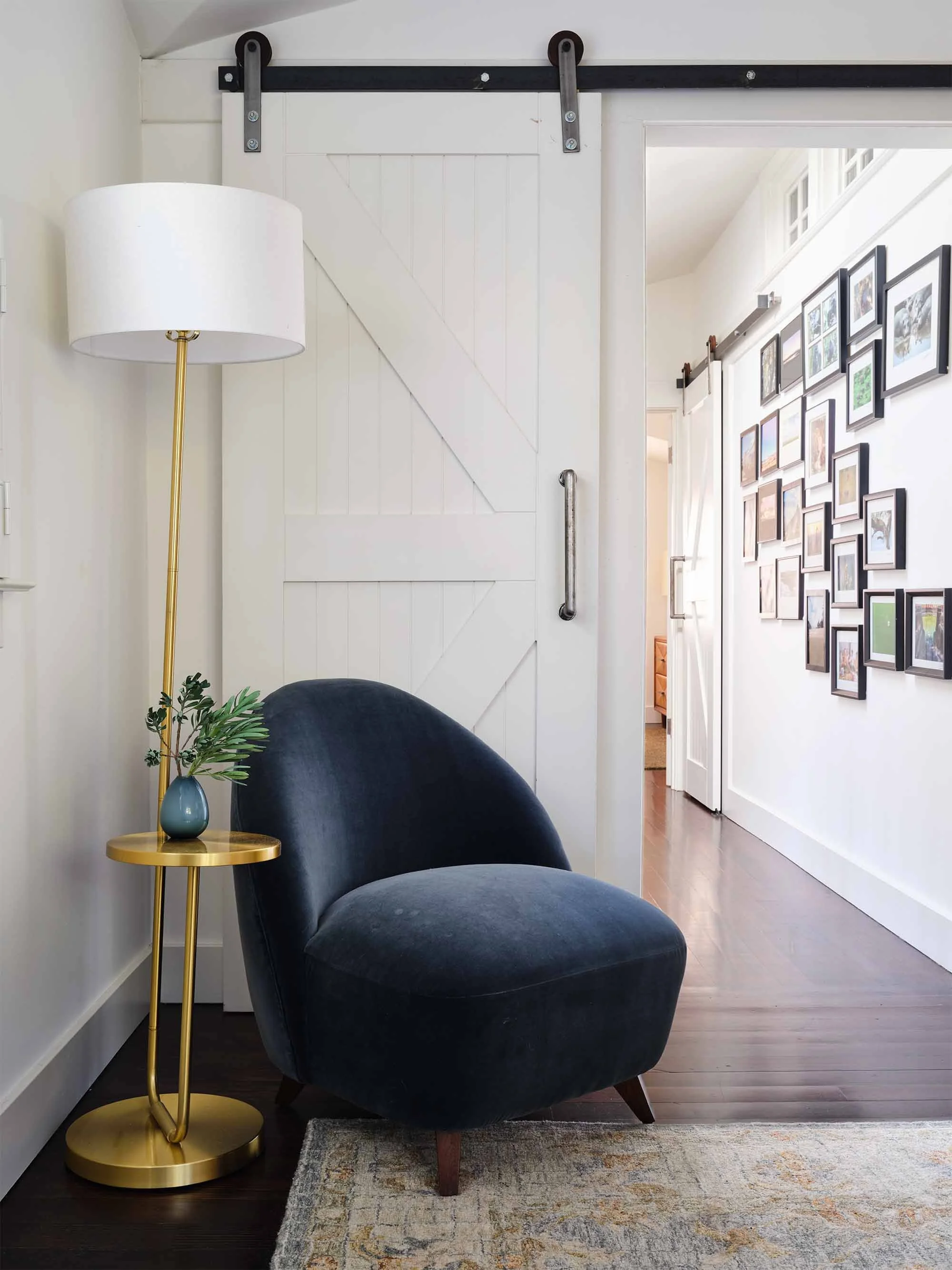 Blue velvet chair vignette beside sliding barn door, designed by JKB Home Design for San Anselmo home