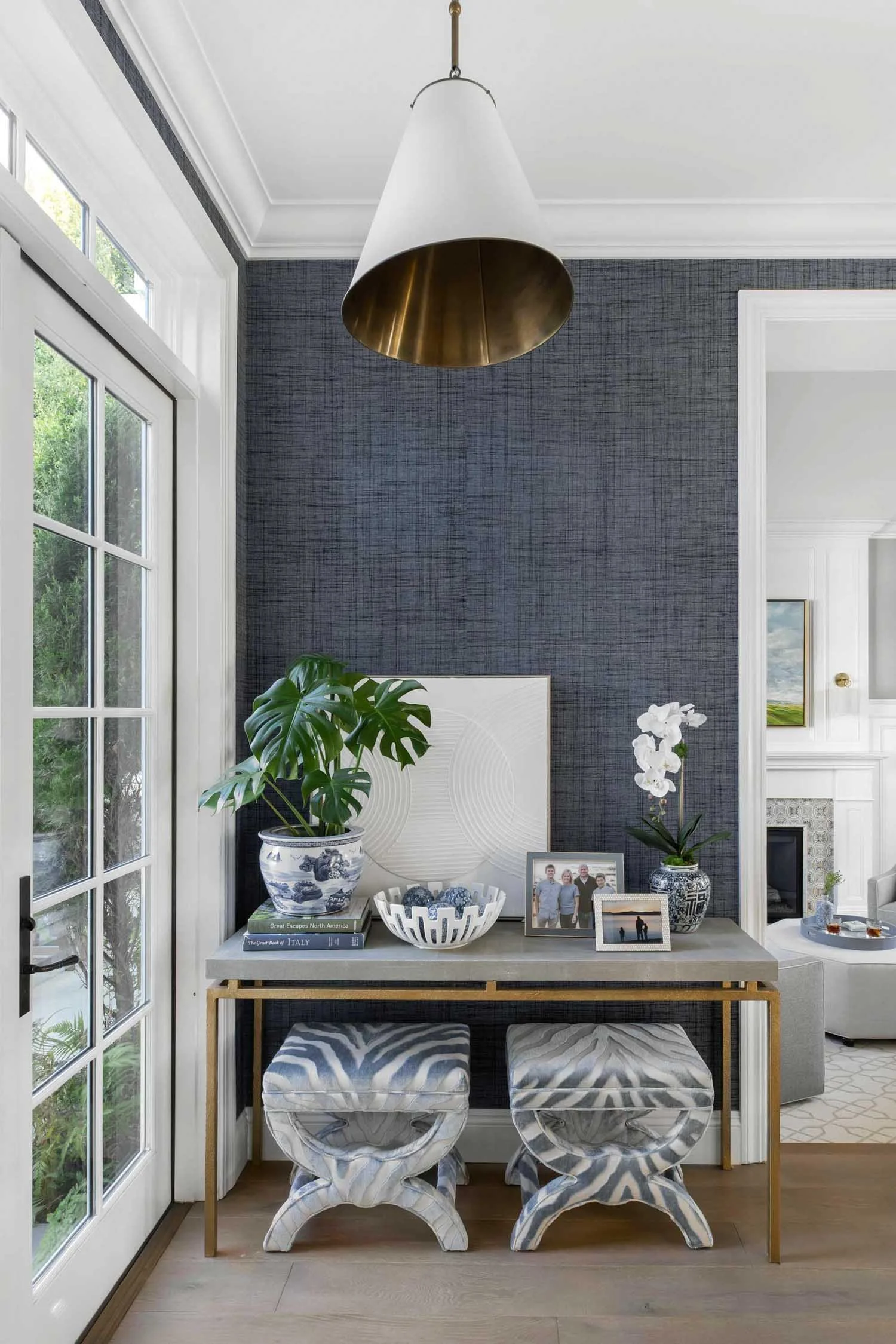 Pacific Palisades formal entry with upholstered stools and plant accents, designed by JKB Home Design