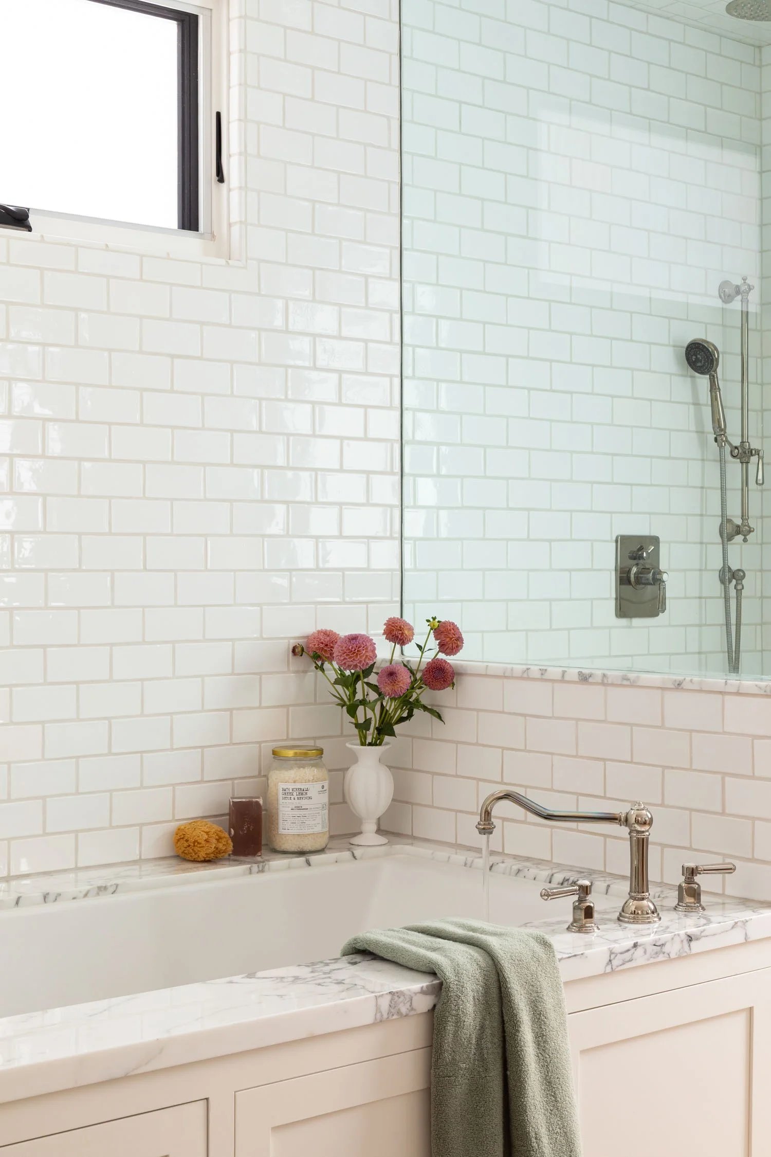 Built-in bathtub with white subway tile, marble surround, and glass shower in a Manhattan Beach bathroom by JKB Home Design