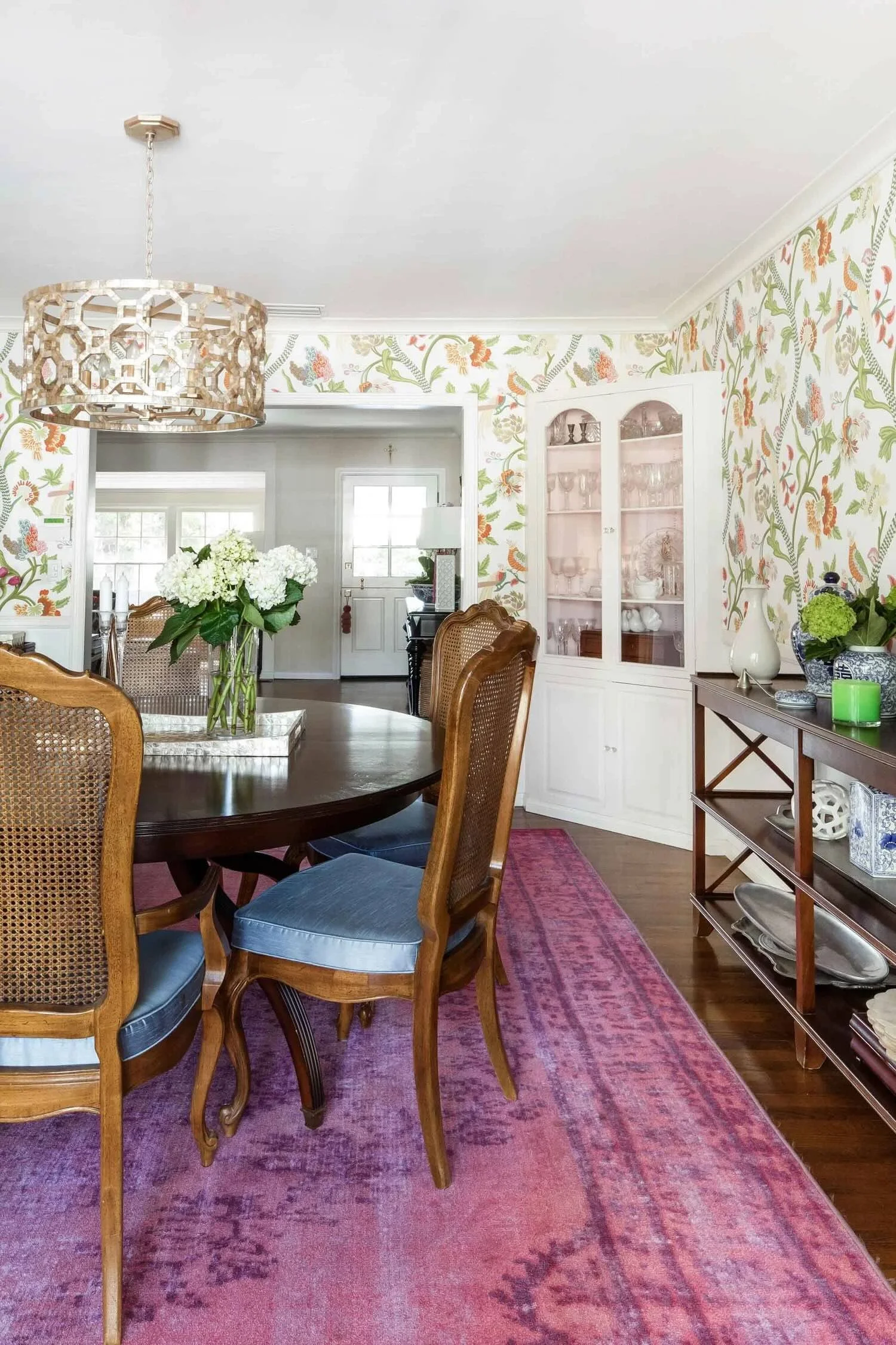 Elegant round dining table with magenta rug by Julie Beuerlein interior design in California