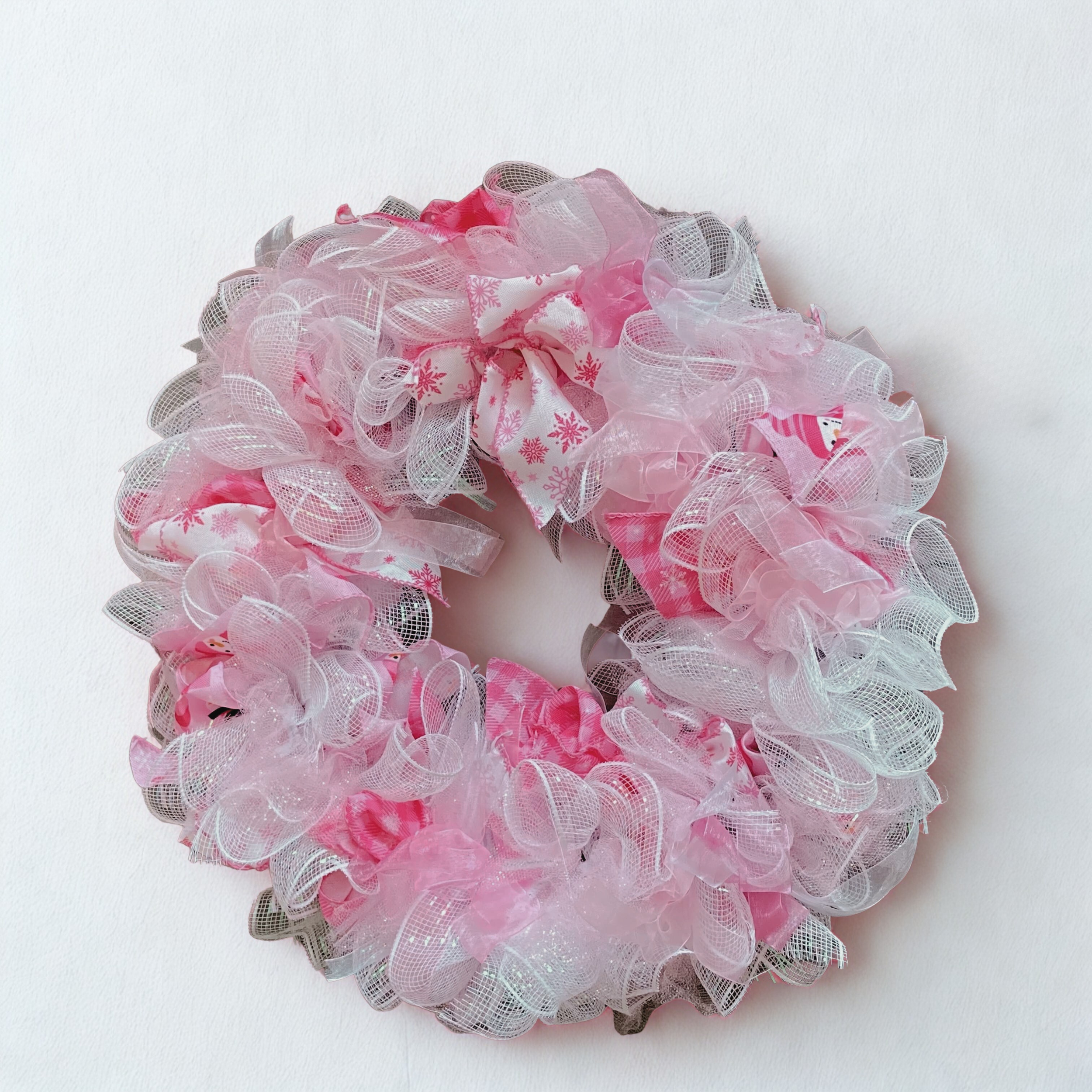 pink snowman wreath white wall.png