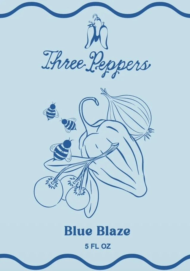 Package of Blue Blaze hot sauce with a drawing of peppers, tomatoes, and bees, and the text 'Three Peppers, Blue Blaze, 5 FL OZ'.