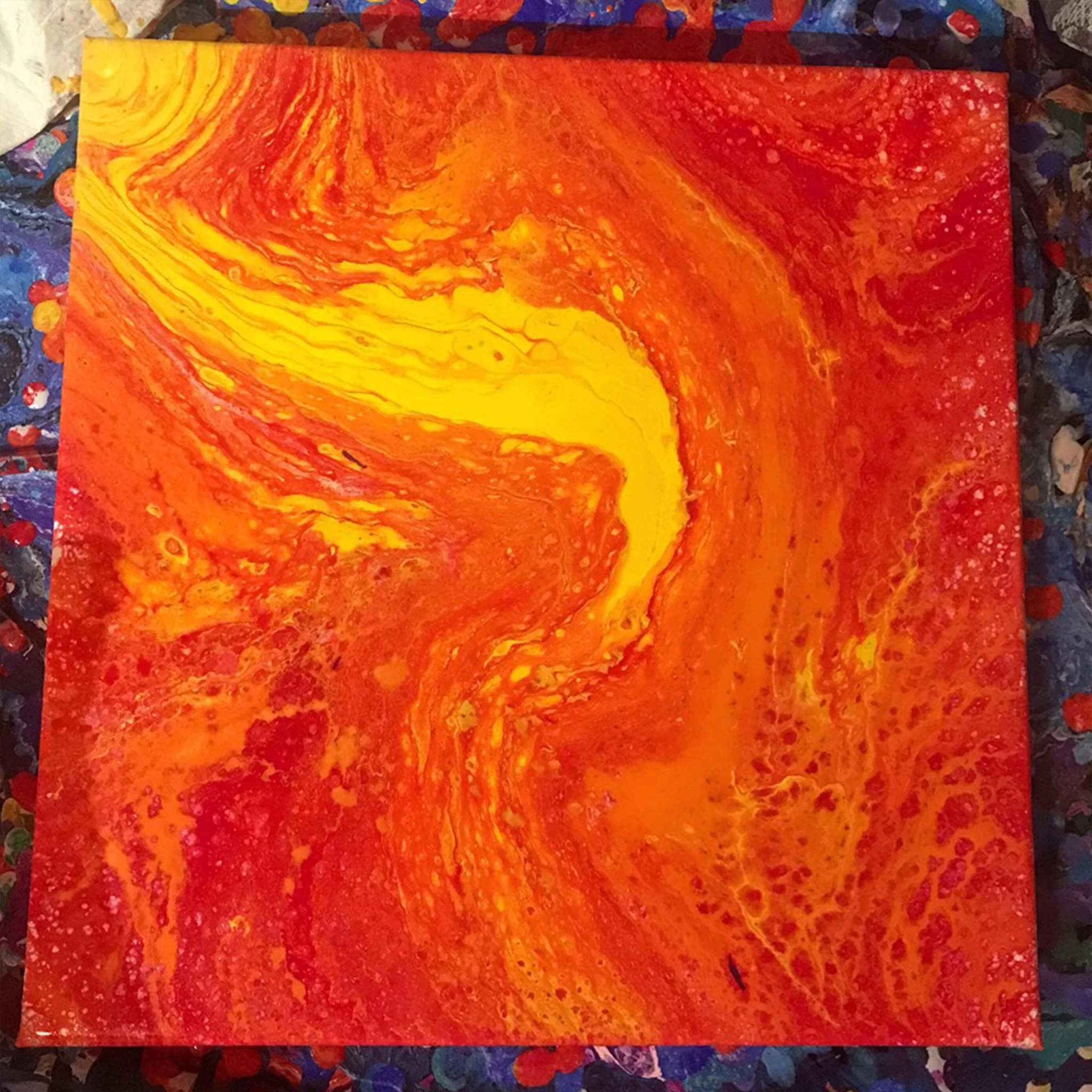 Abstract acrylic painting with swirls of yellow, orange, and red hues.