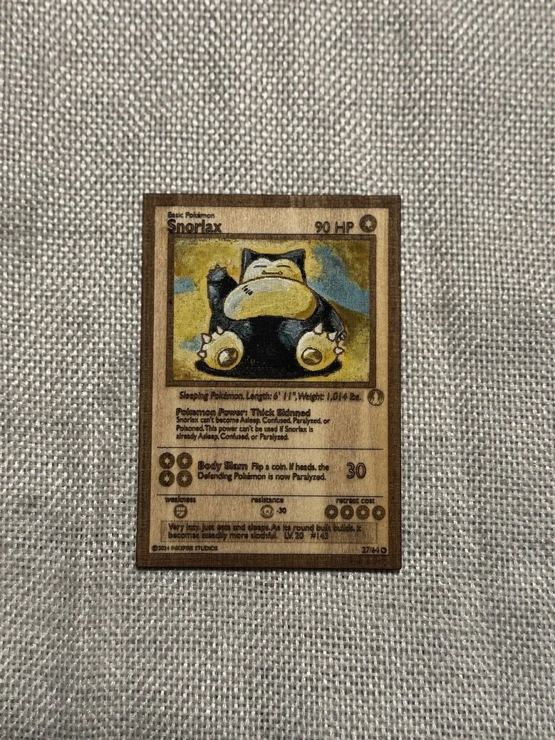 A Pokémon card featuring Snorlax, a sleeping, large, yellow and black Pokémon, with 90 HP, 30 damage Body Slam attack, and a brown border on a light textured background.