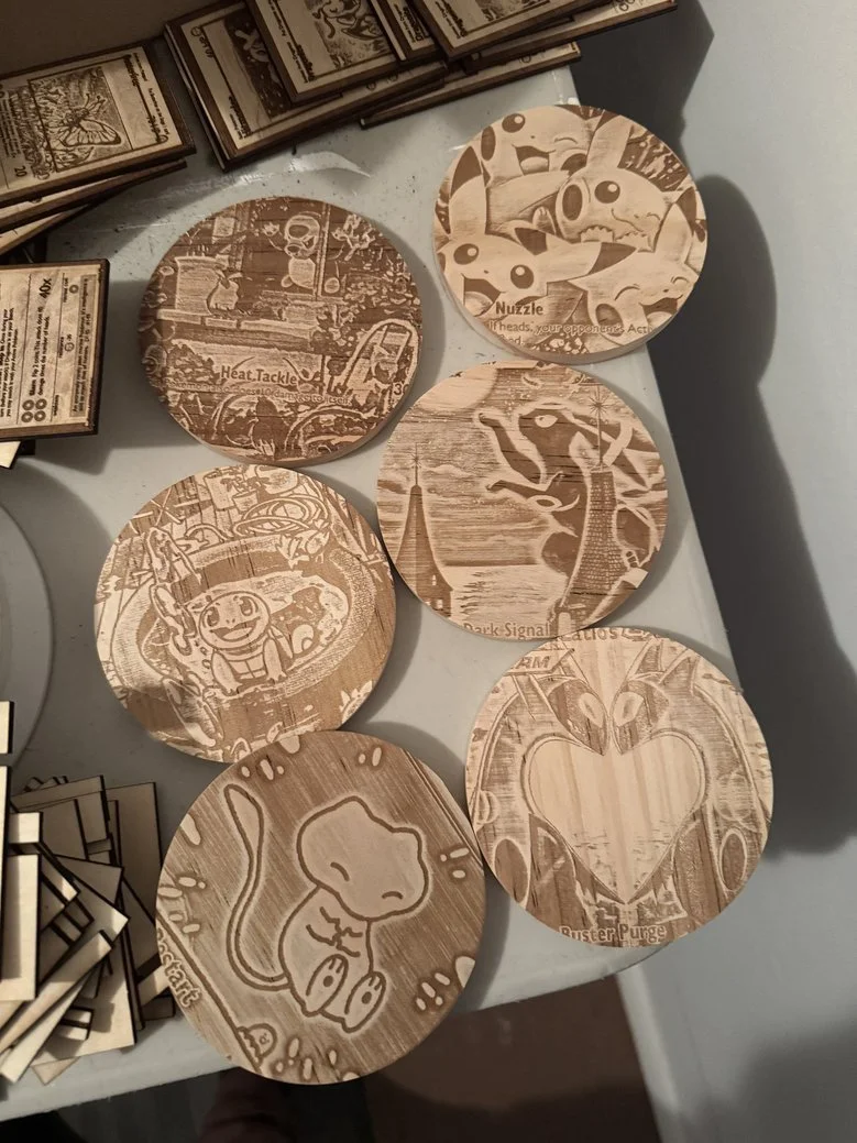 Wooden coasters featuring laser-engraved Pokémon characters and themes, including Pikachu, Jigglypuff, and Eevee.