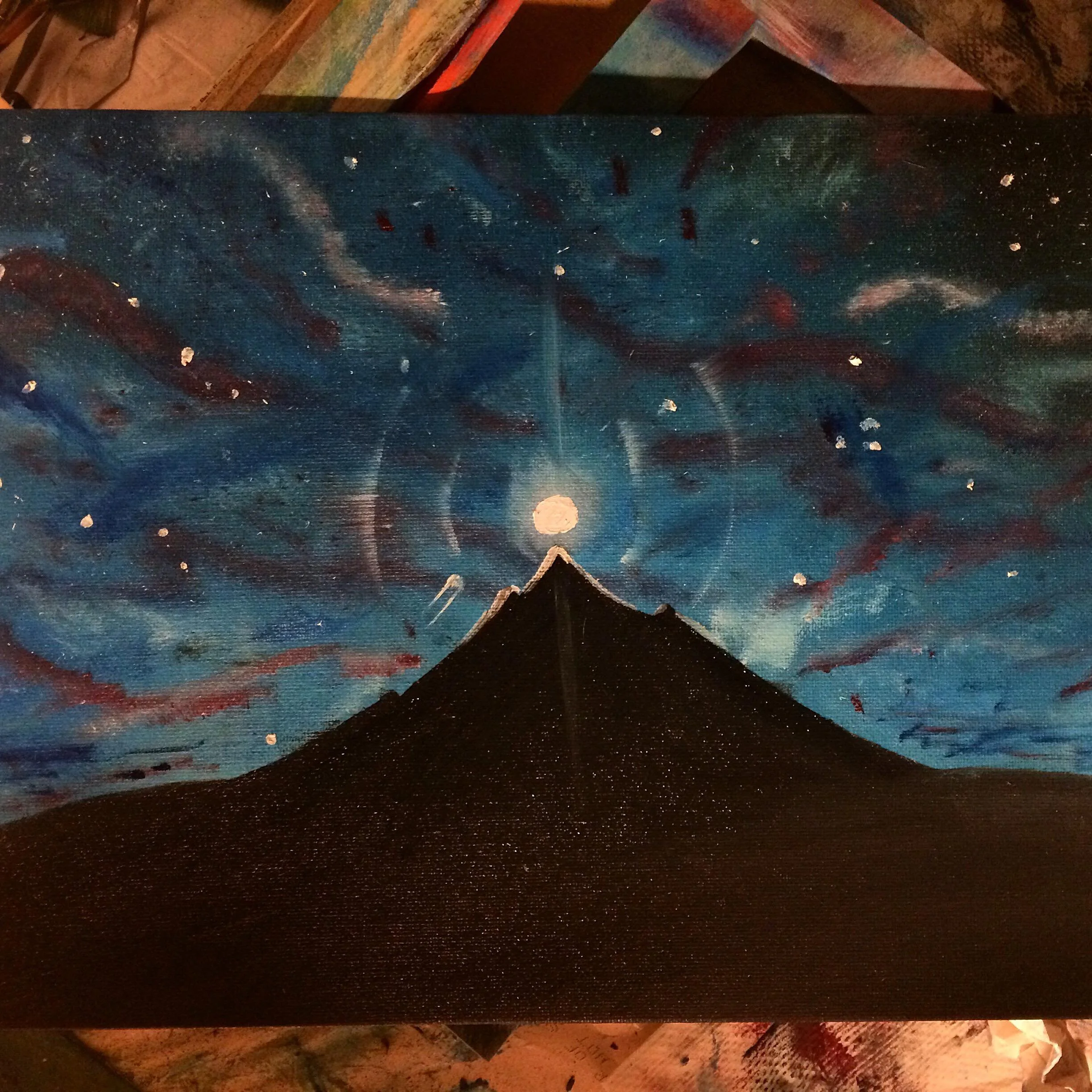 A painting of a mountain at night under a colorful, swirling sky with stars and a bright moon.