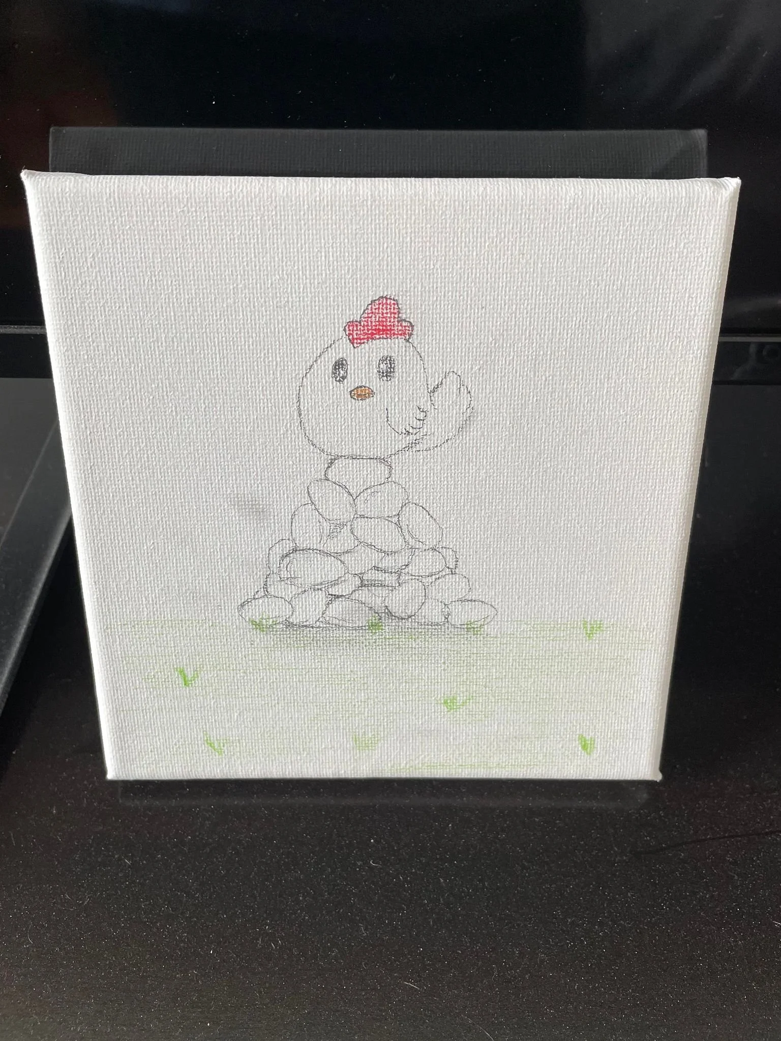 A canvas with a hand-drawn illustration of a chick standing on a pile of rocks, wearing a red hat, and surrounded by small green grass blades.