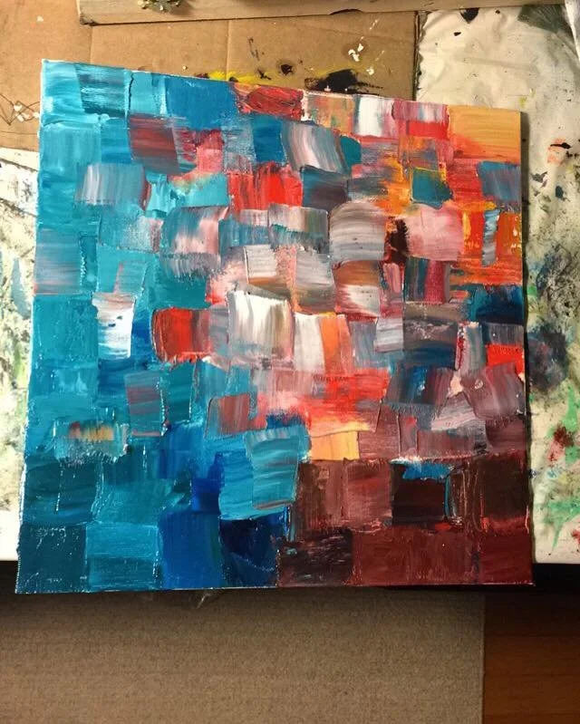 Abstract painting with blue, red, pink, white, orange, and black brushstrokes on canvas.
