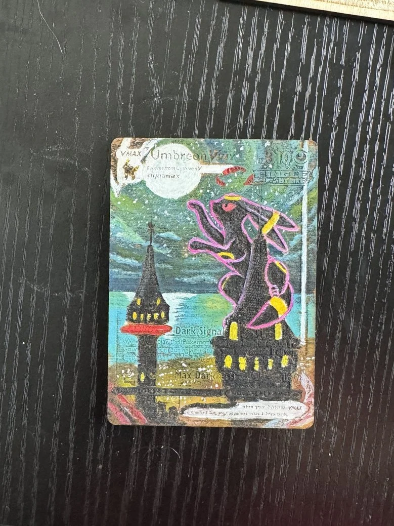 A colorful, stylized illustration of a dark cityscape featuring towers with pointed roofs and yellow windows, a full moon in the sky, and a large, neon pink and yellow dragon coiled around one of the towers, on what appears to be a playing card or st