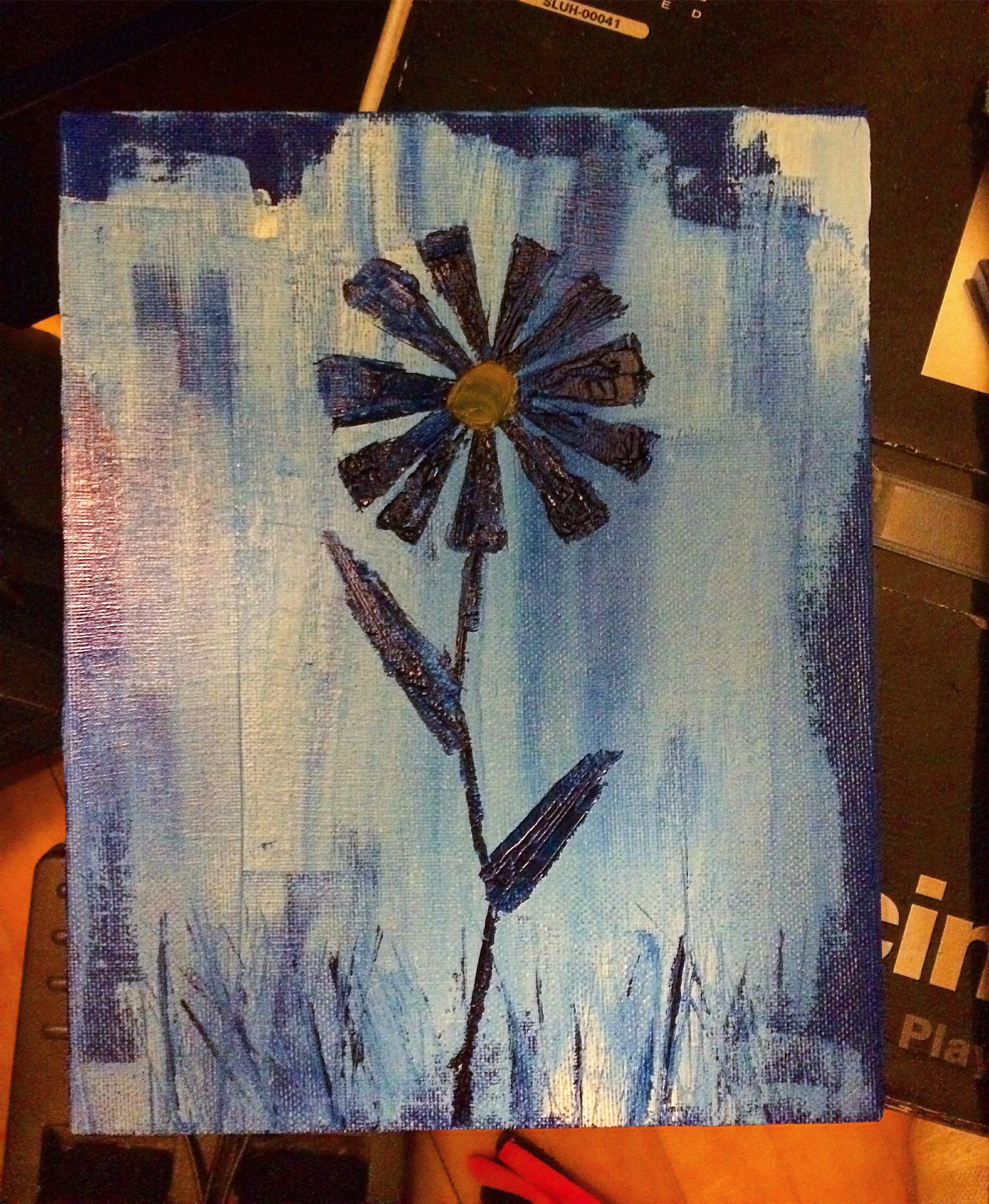 Painting of a flower with a yellow center and dark petals on a textured blue background.