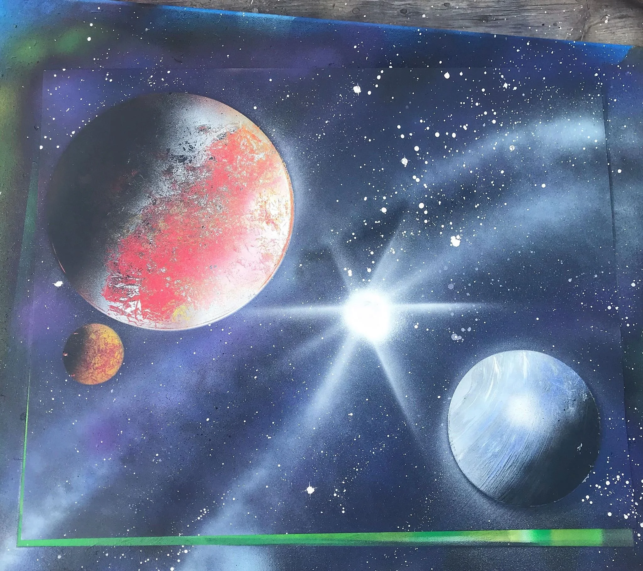 Space-themed spray paint art depicting three planets and a bright star in a starry galaxy background.