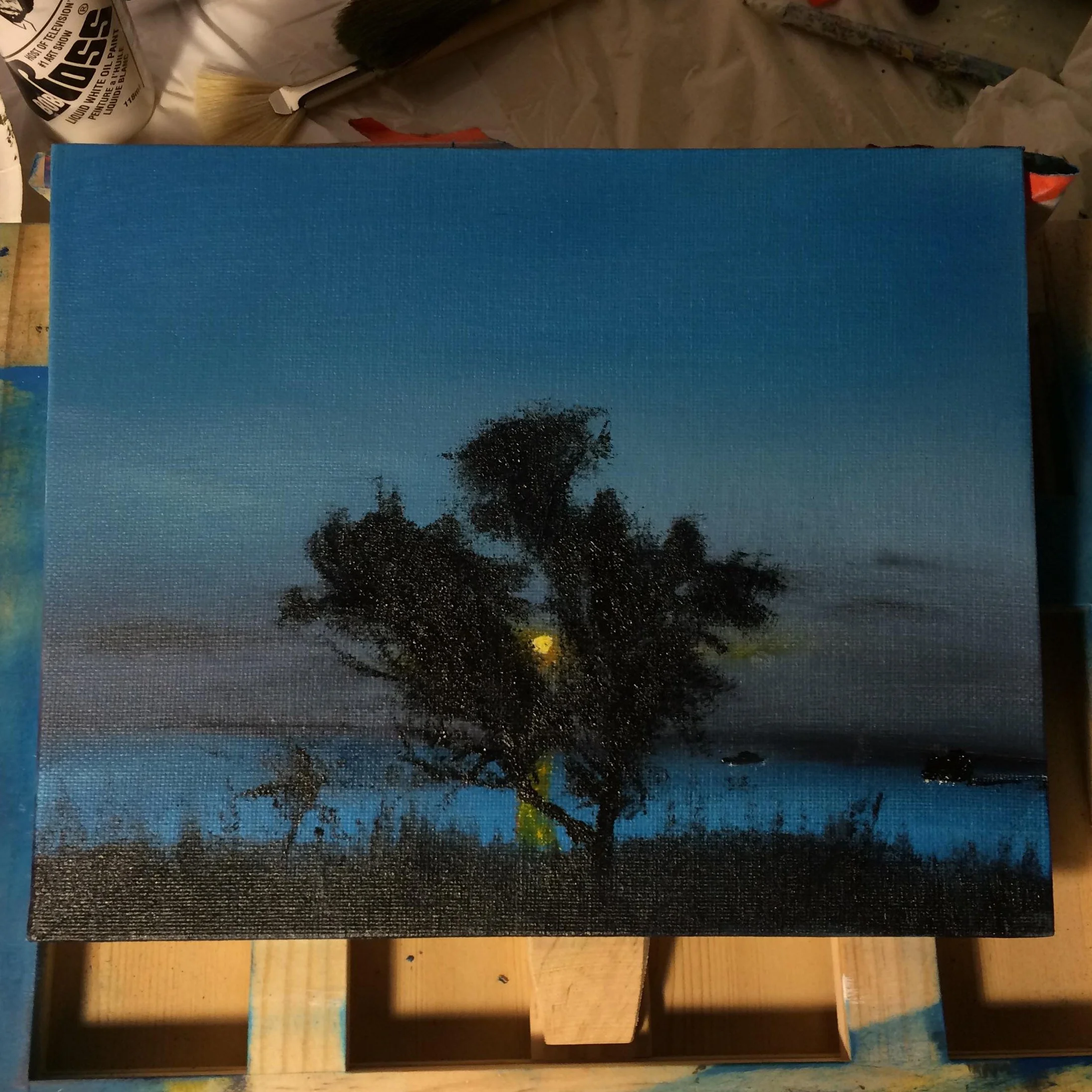 A painting of a landscape at dusk with a large tree near a body of water and the moon in the sky.