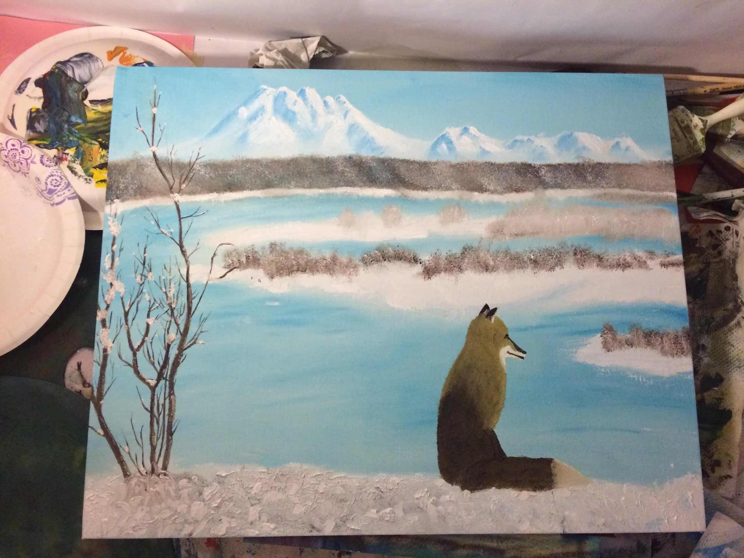 A painting of a winter landscape featuring a mountain with snow, a lake, and a sitting wolf in the foreground.