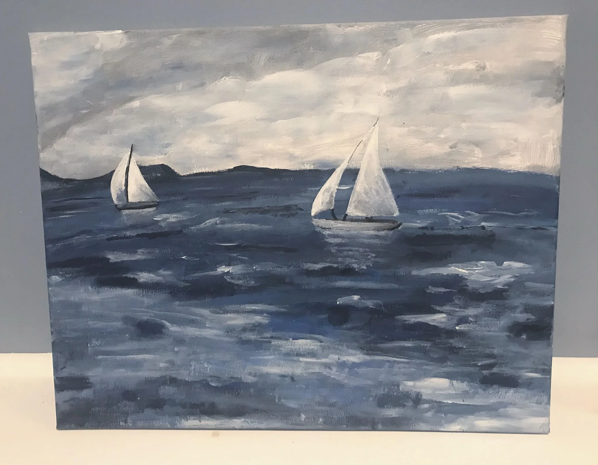 Painting of three sailboats on a gray and blue ocean under a cloudy sky with distant land on the horizon.